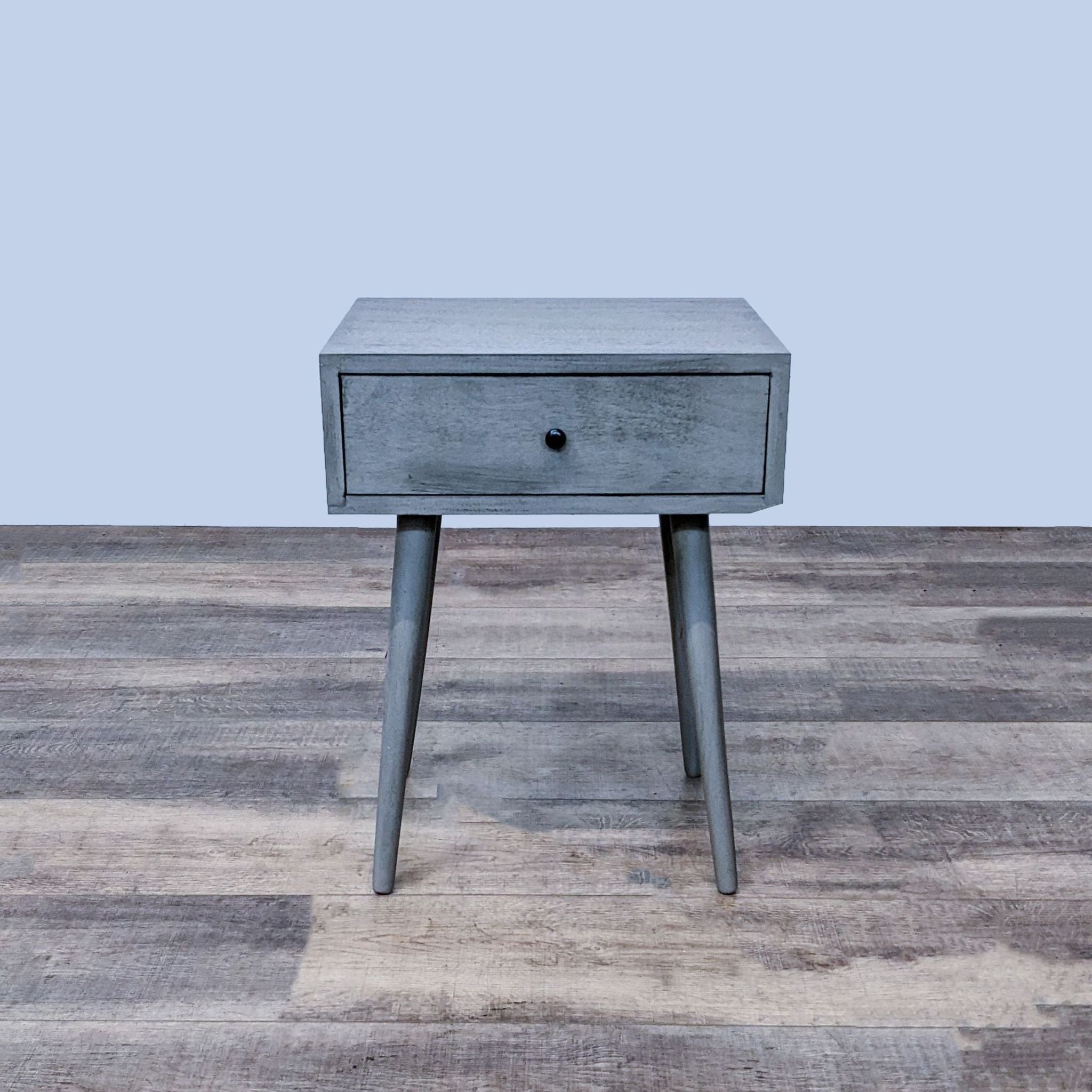 Reperch brand end table with a single gray drawer and angled legs on a wooden floor.