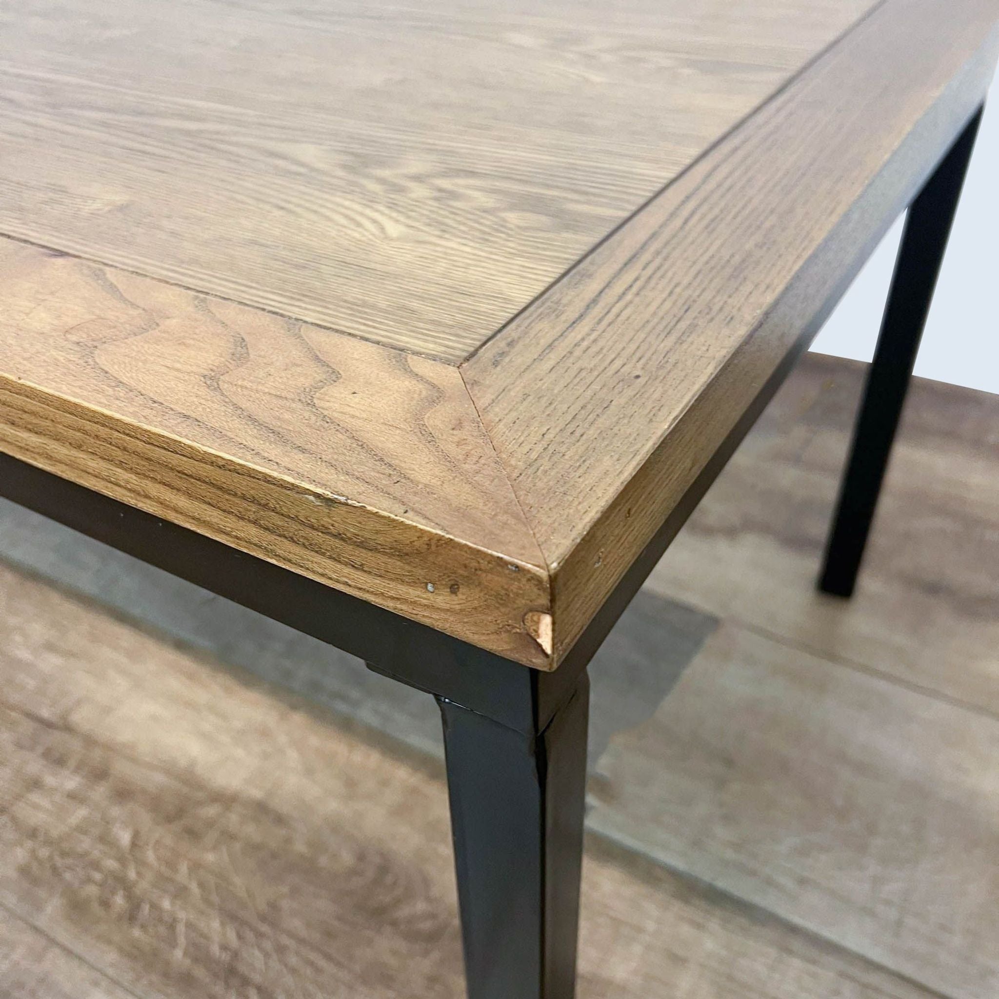 Close-up of Reperch coffee table corner showing the wood grain texture and metal leg attachment.