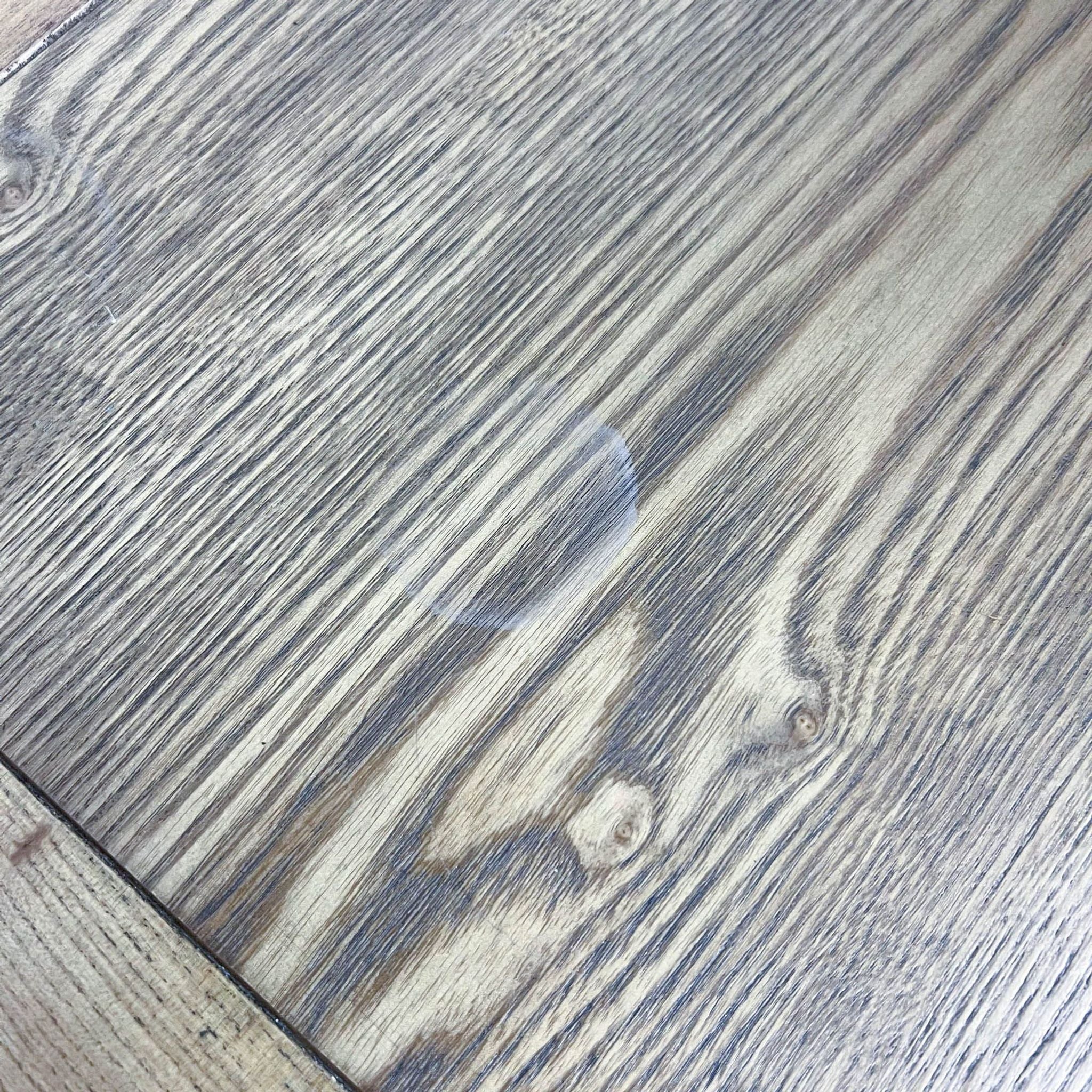 Close-up texture of a Reperch coffee table with a whitewashed wood grain finish.