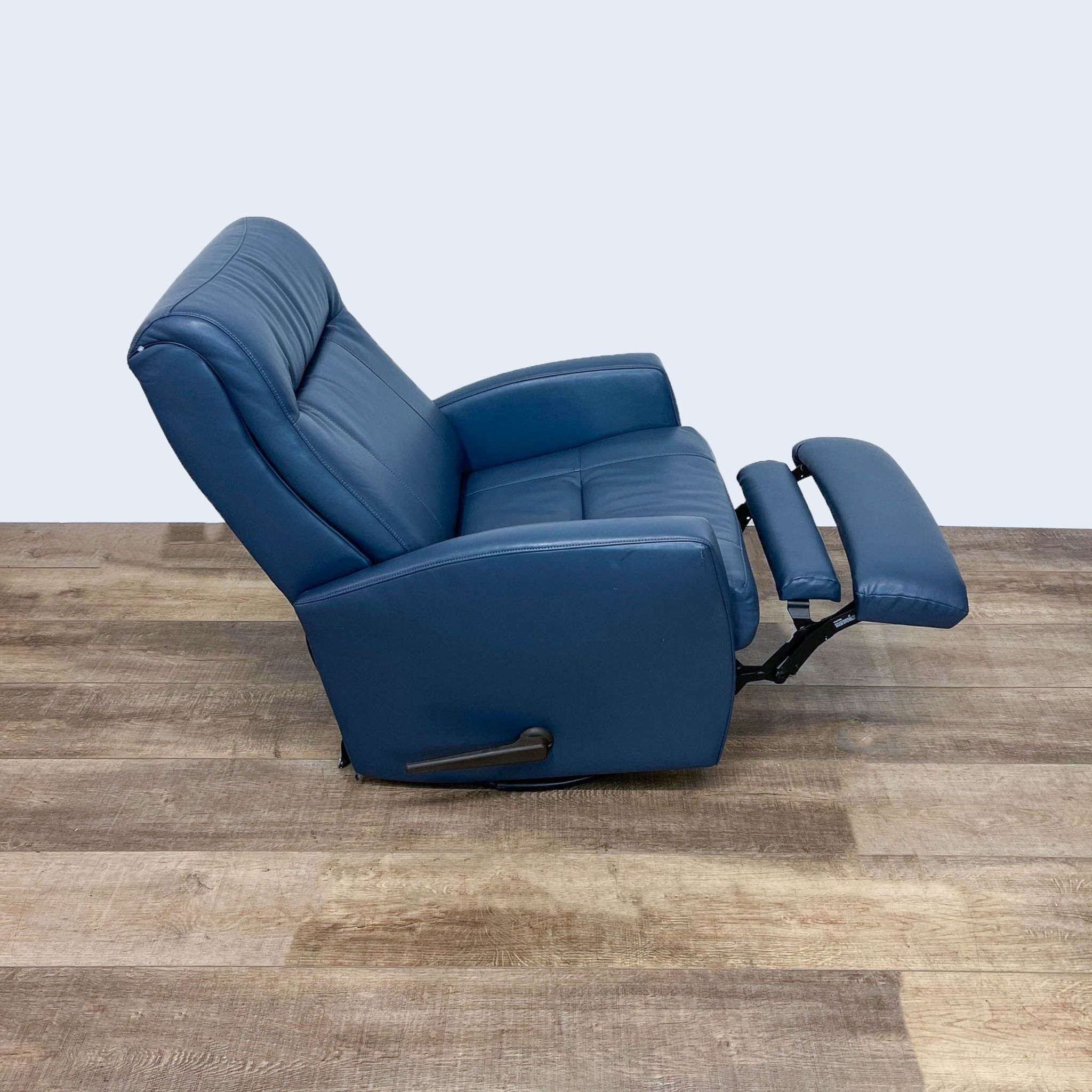 Reclined position of Reperch leather recliner showing manual recline function, with footrest extended on a swivel base.