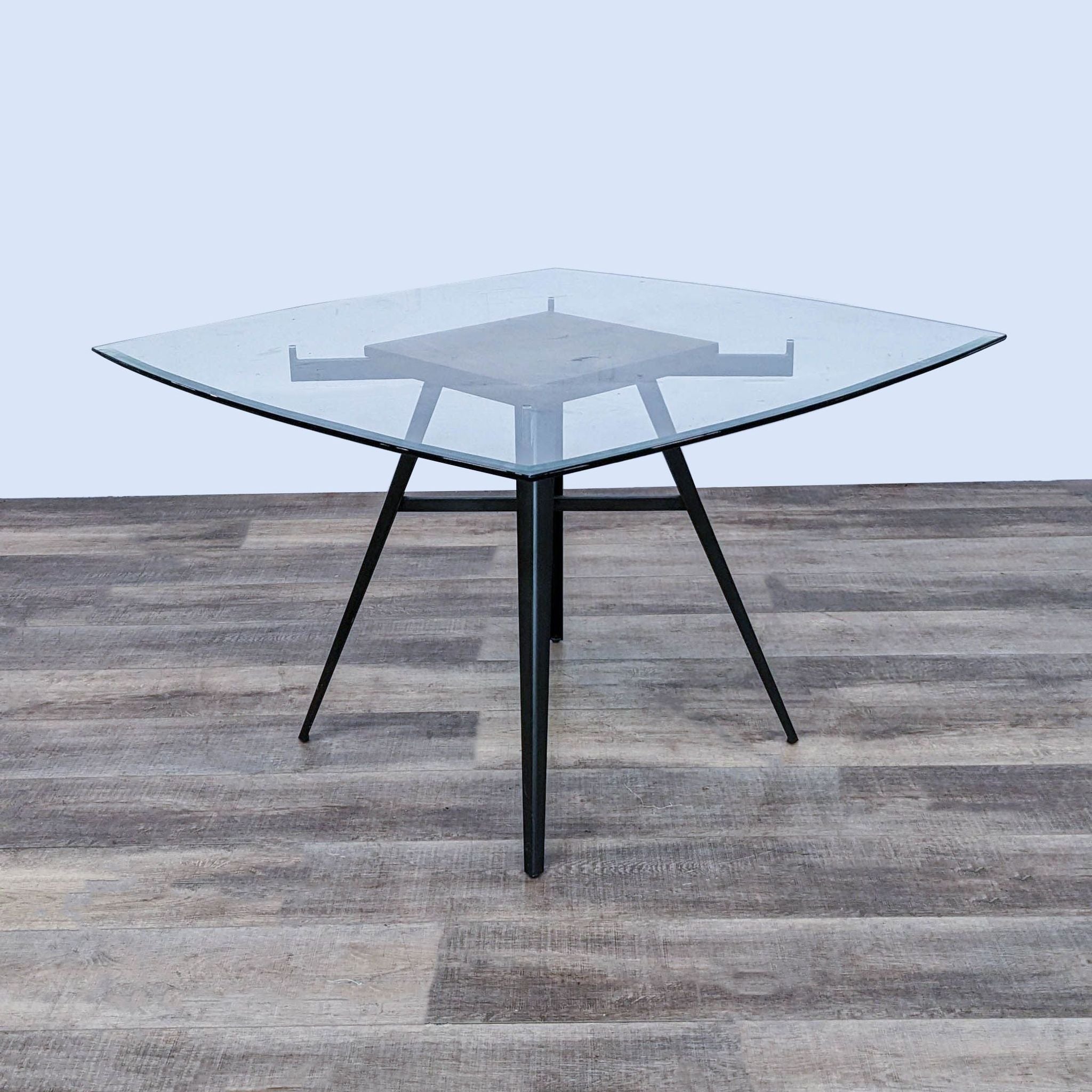 Ojai contemporary dining table by Armen Living with clear tempered glass top and stylized mineral finish metal base.