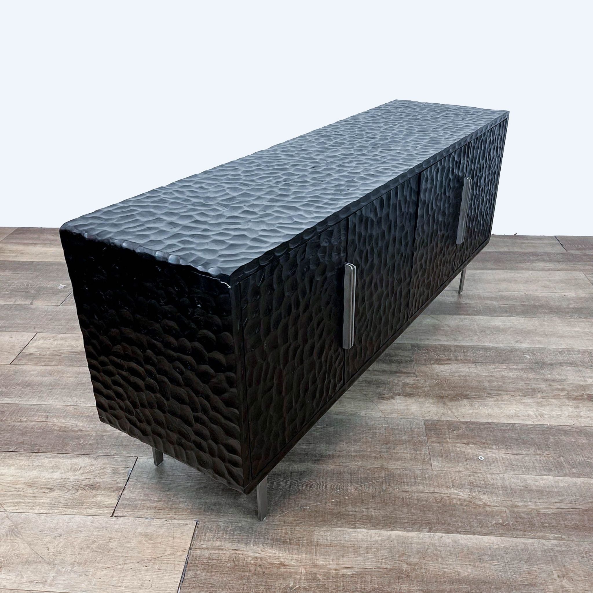 Blackened mango wood credenza with hand-carved moulded effect by Mermelada Estudio on a stainless steel base for CB2, with cord management.