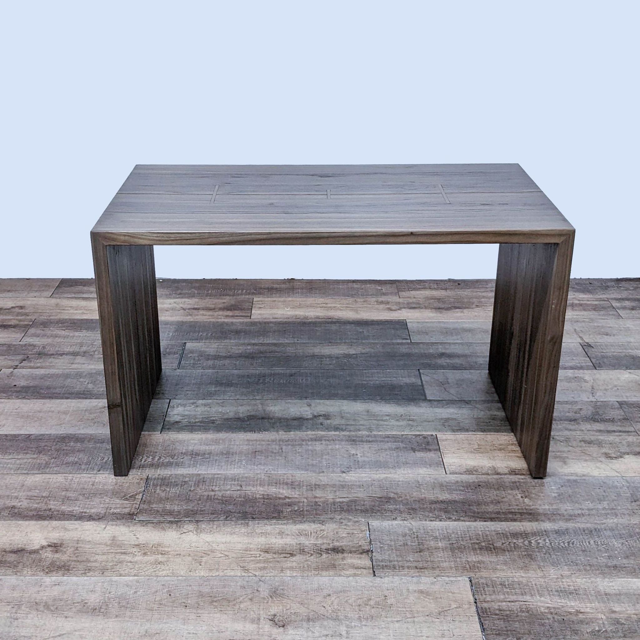 Crate & Barrel's Maxwell Waterfall dining table featuring elm wood planks with brass inlay on a wood floor.