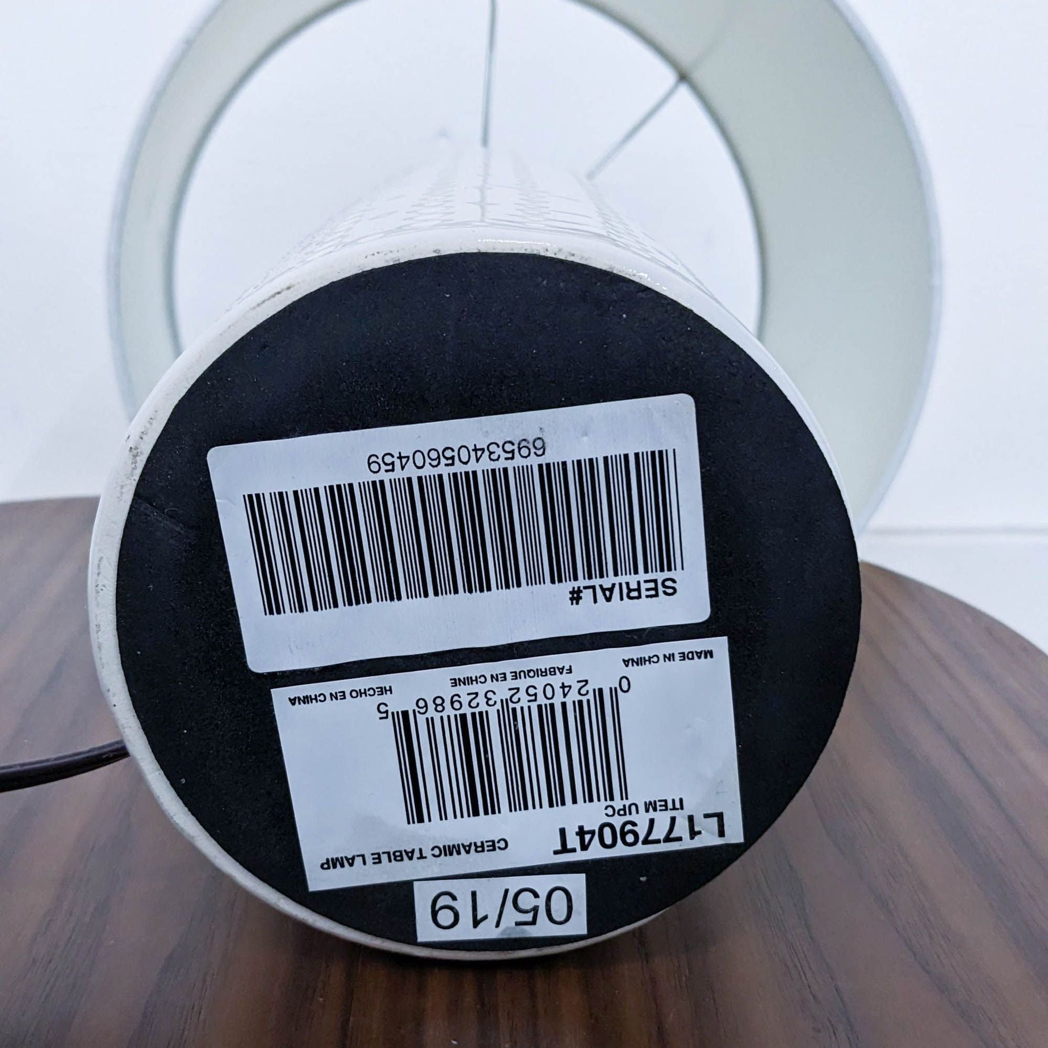 Close-up of a Reperch brand lighting product's base with a barcode and label on a reflective surface.