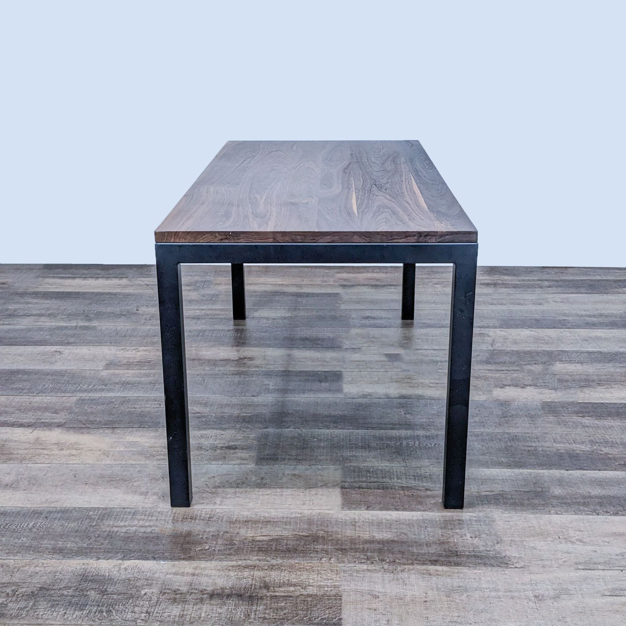 Angle view of Parsons table by Room & Board, showcasing the walnut finish wood top and the craftsmanship of the steel base.
