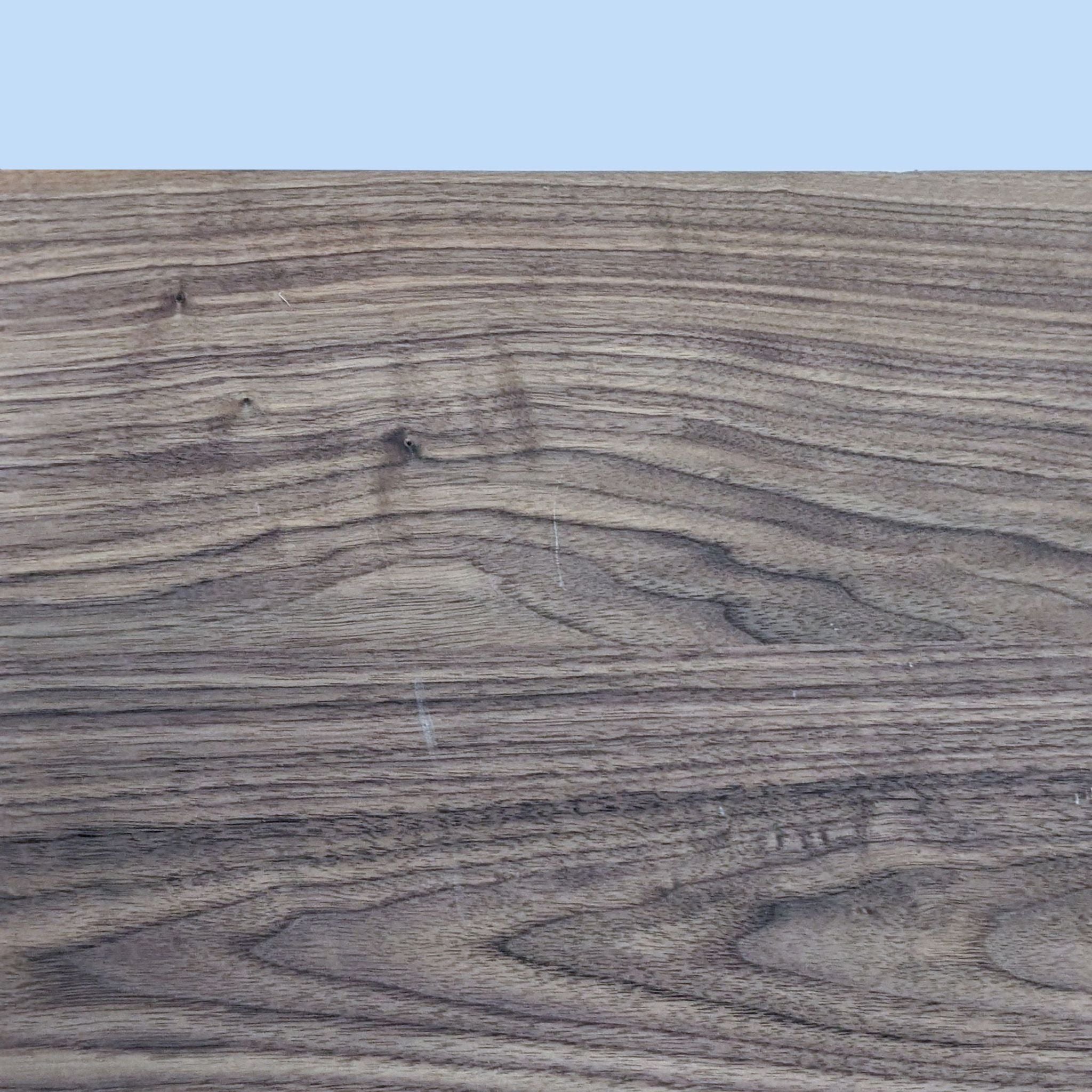 Close-up of Room & Board Parsons dining table's walnut-stained wood top, showing wood grain detail.