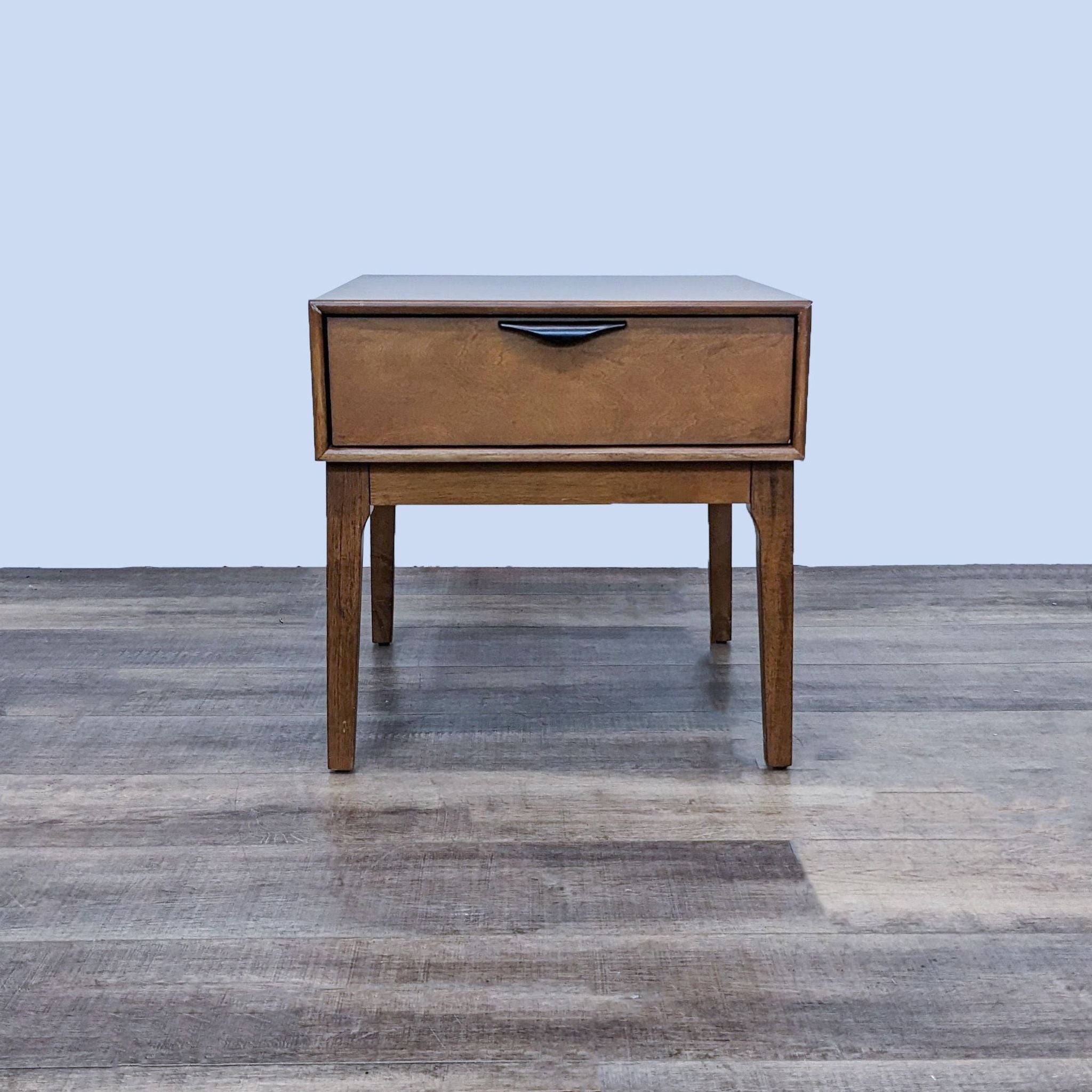 Reperch brand end table with closed drawer, wooden finish, standing on a wood textured floor against a light background.