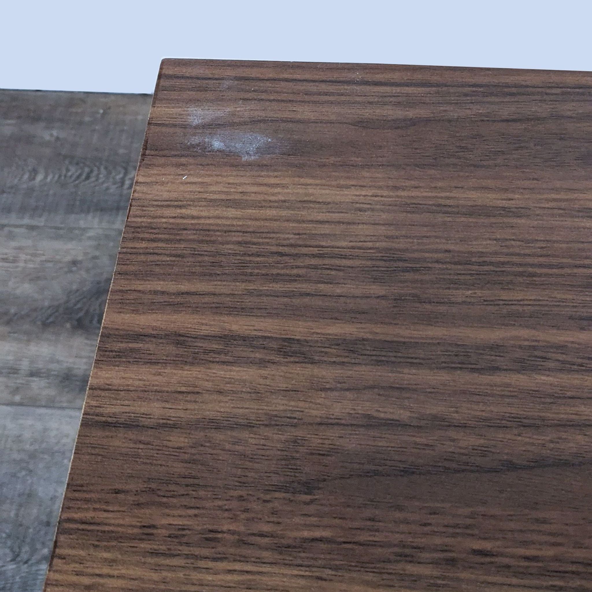 Close-up of Reperch end table surface showing wooden texture and a small white scuff mark on the right side.
