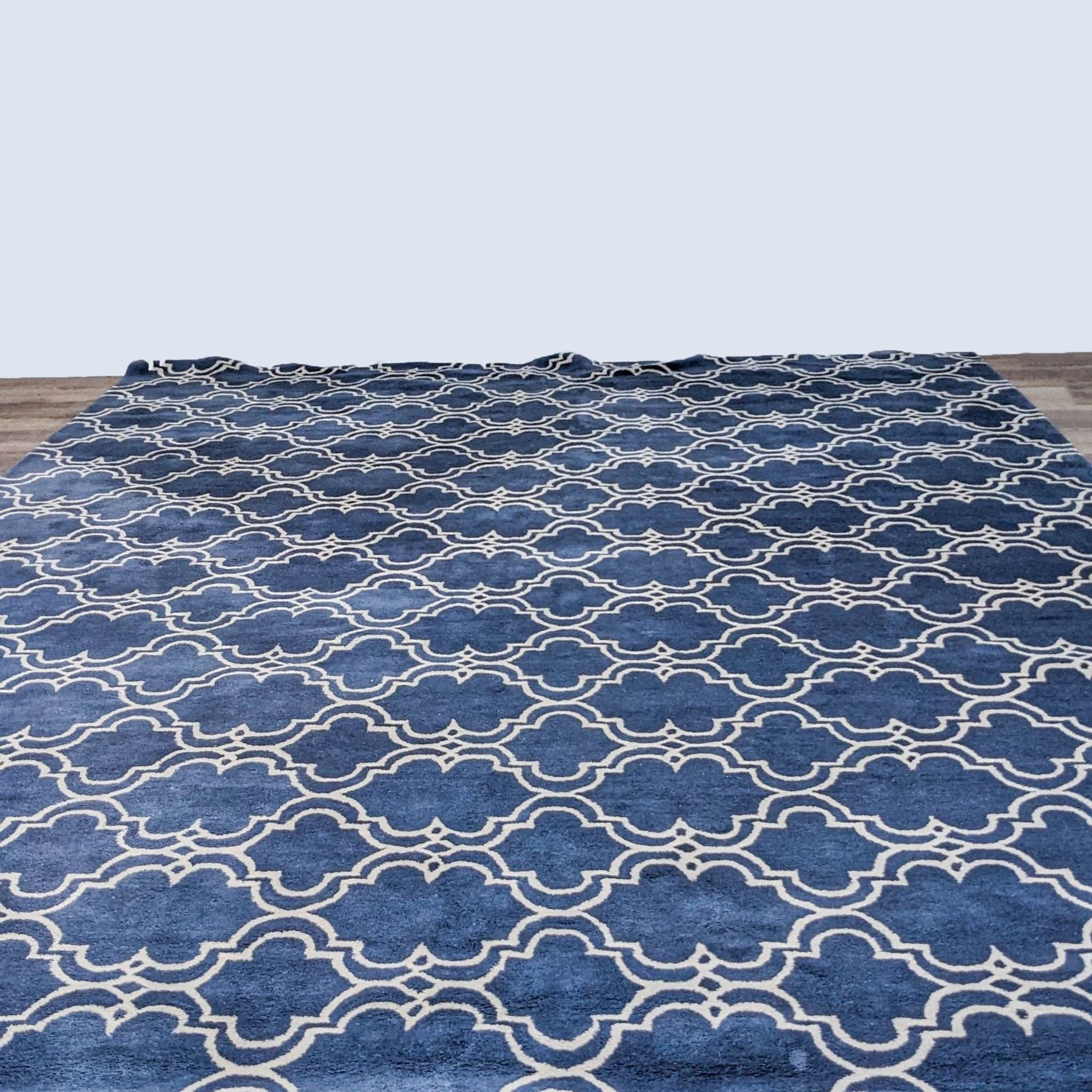 Pottery Barn blue and white patterned rug on wooden floor.
