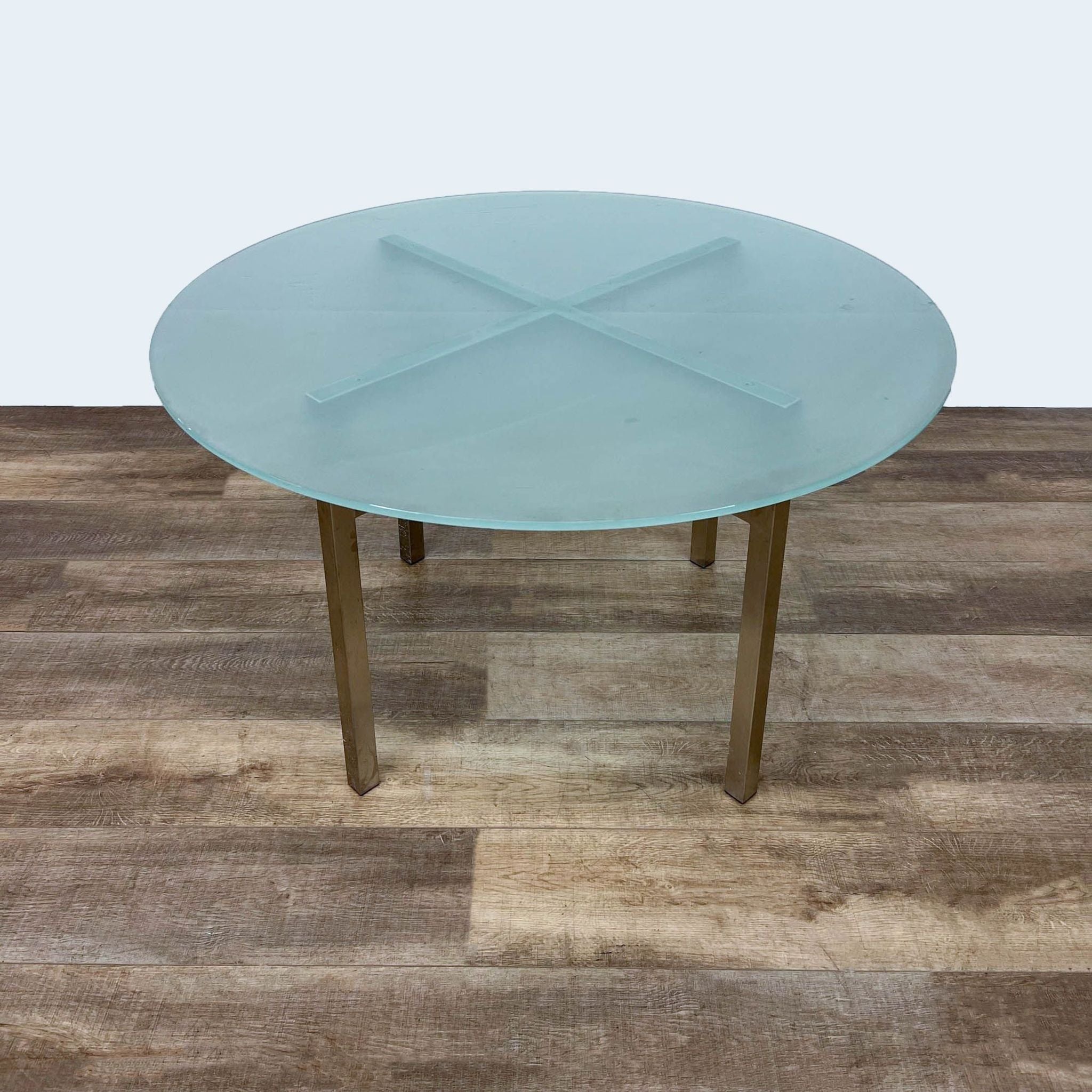 Room & Board's Benson round dining table featuring a tempered frosted glass top and a gold finish metal base.
