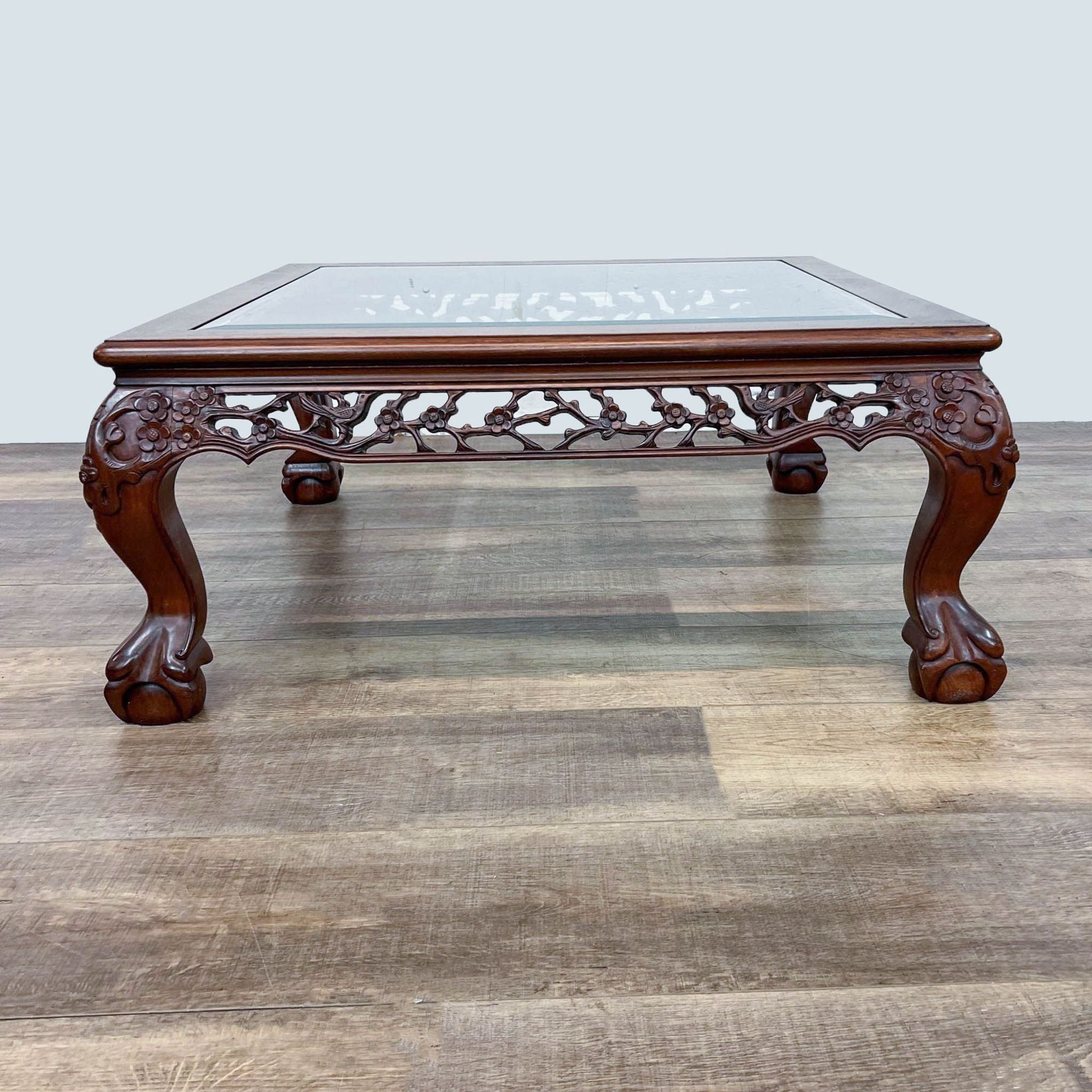 Reperch brand Chinese Chippendale style coffee table with ornate carvings and ball and claw feet.