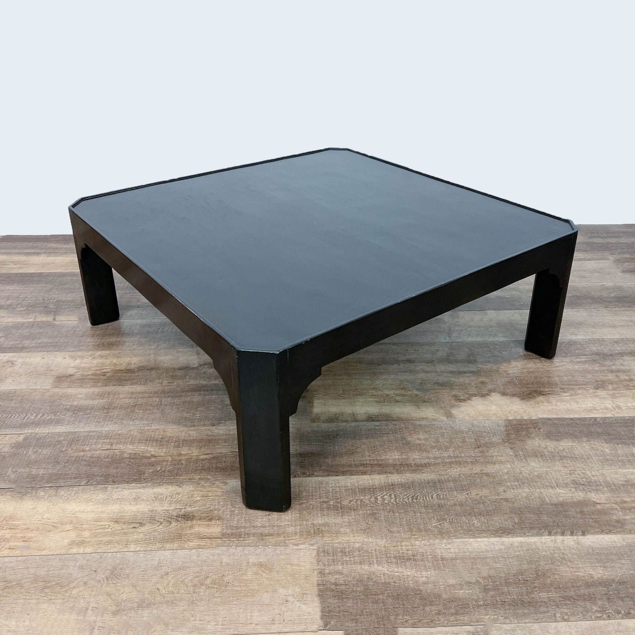 Black square Dennis & Leen coffee table on wooden flooring.