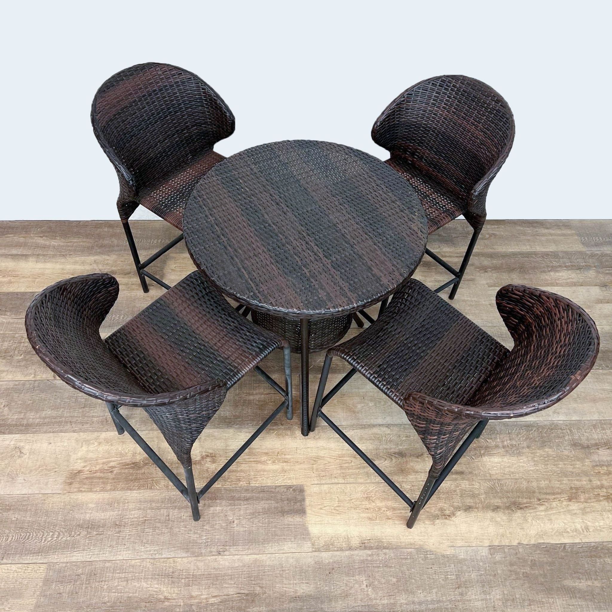Round resin wicker table set by Reperch with four chairs, viewed from above, showcasing the set's compact design.