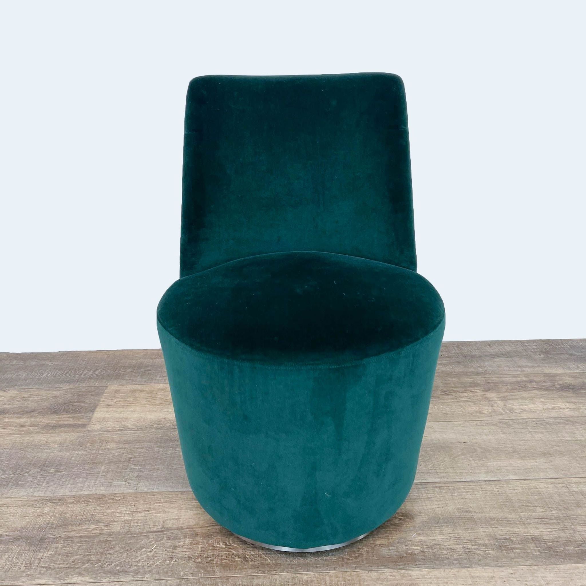 Alt text 1: Plush hunter green velvet dining chair by Crate & Barrel with cushioned seating and a solid-body design on a wooden floor.