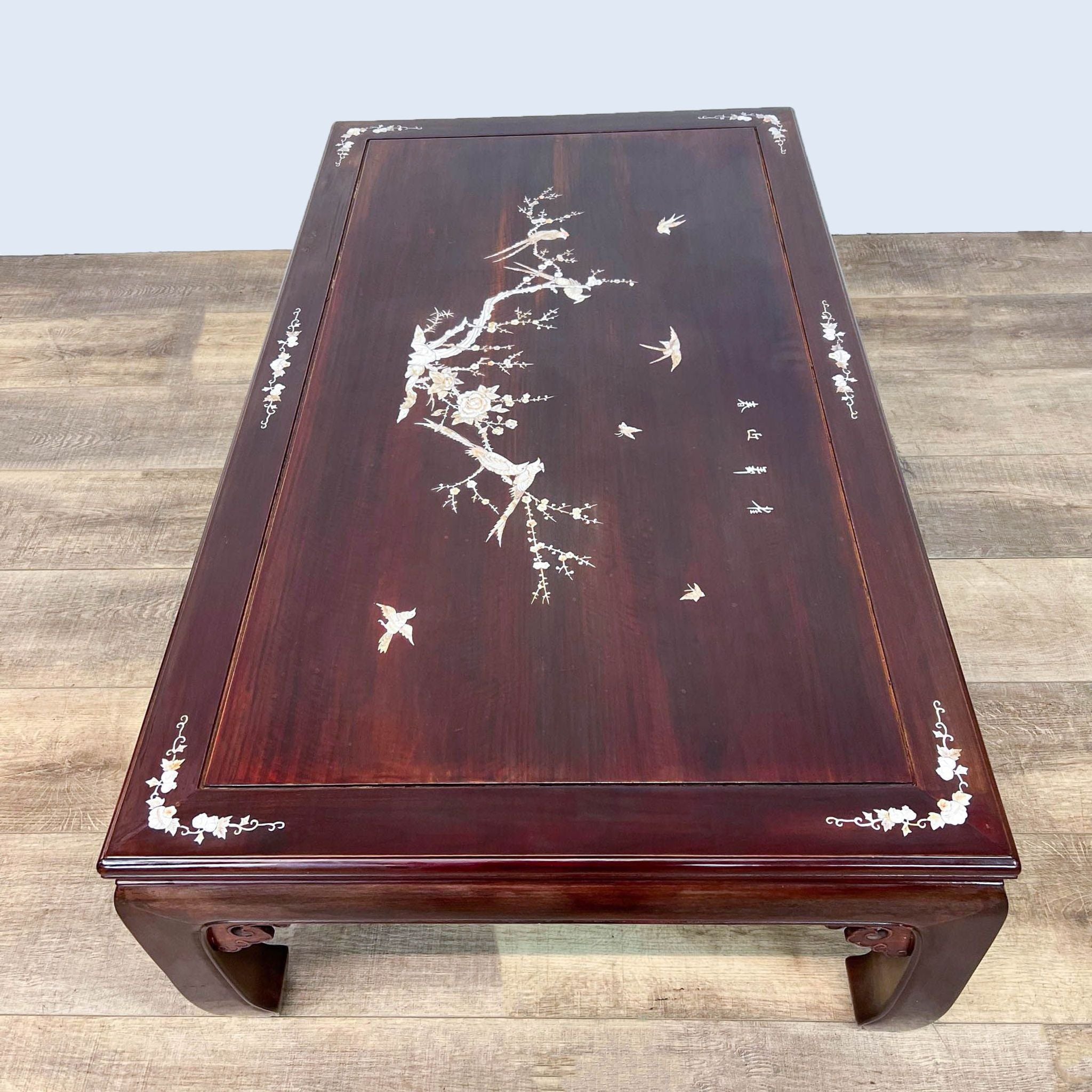 Reperch-brand coffee table with Mother of Pearl inlay depicting a cherry blossom motif on a dark wood background.