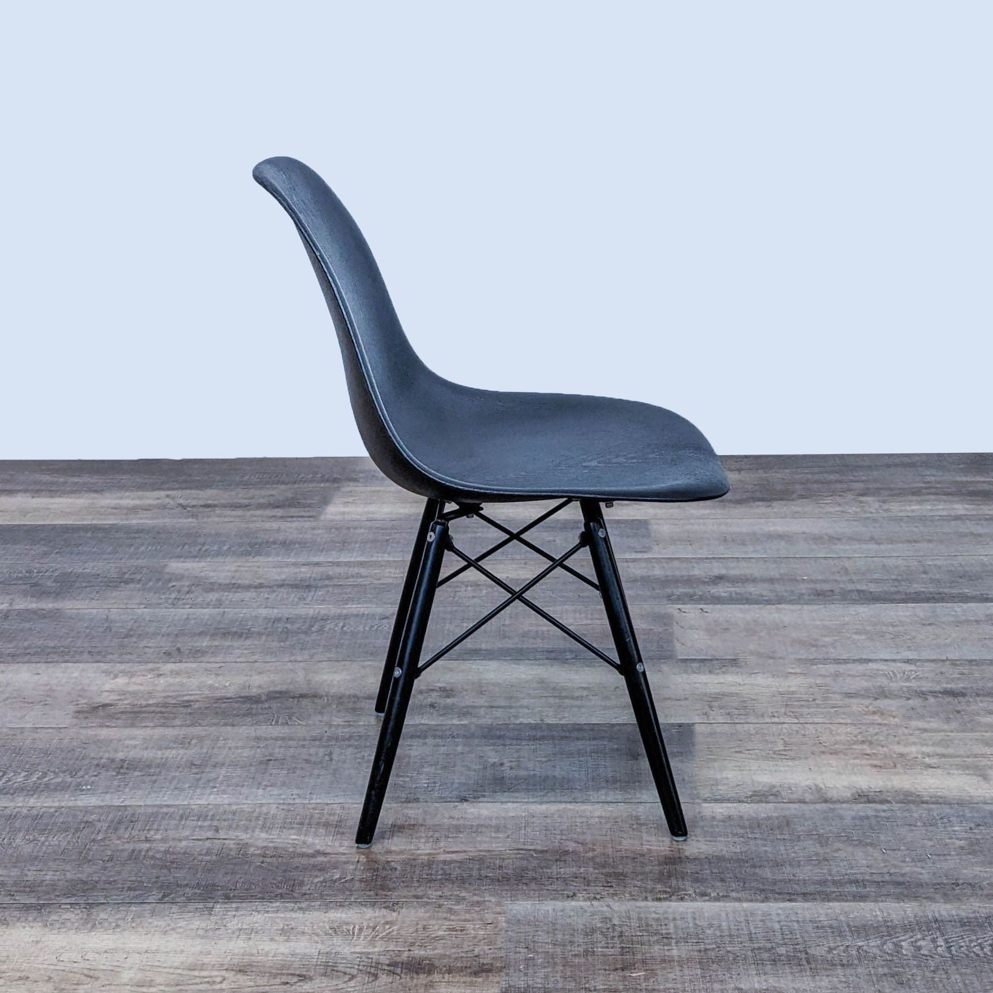 Reperch modern dining chair with black moulded seat and Eiffel metal base, shown from a side angle.