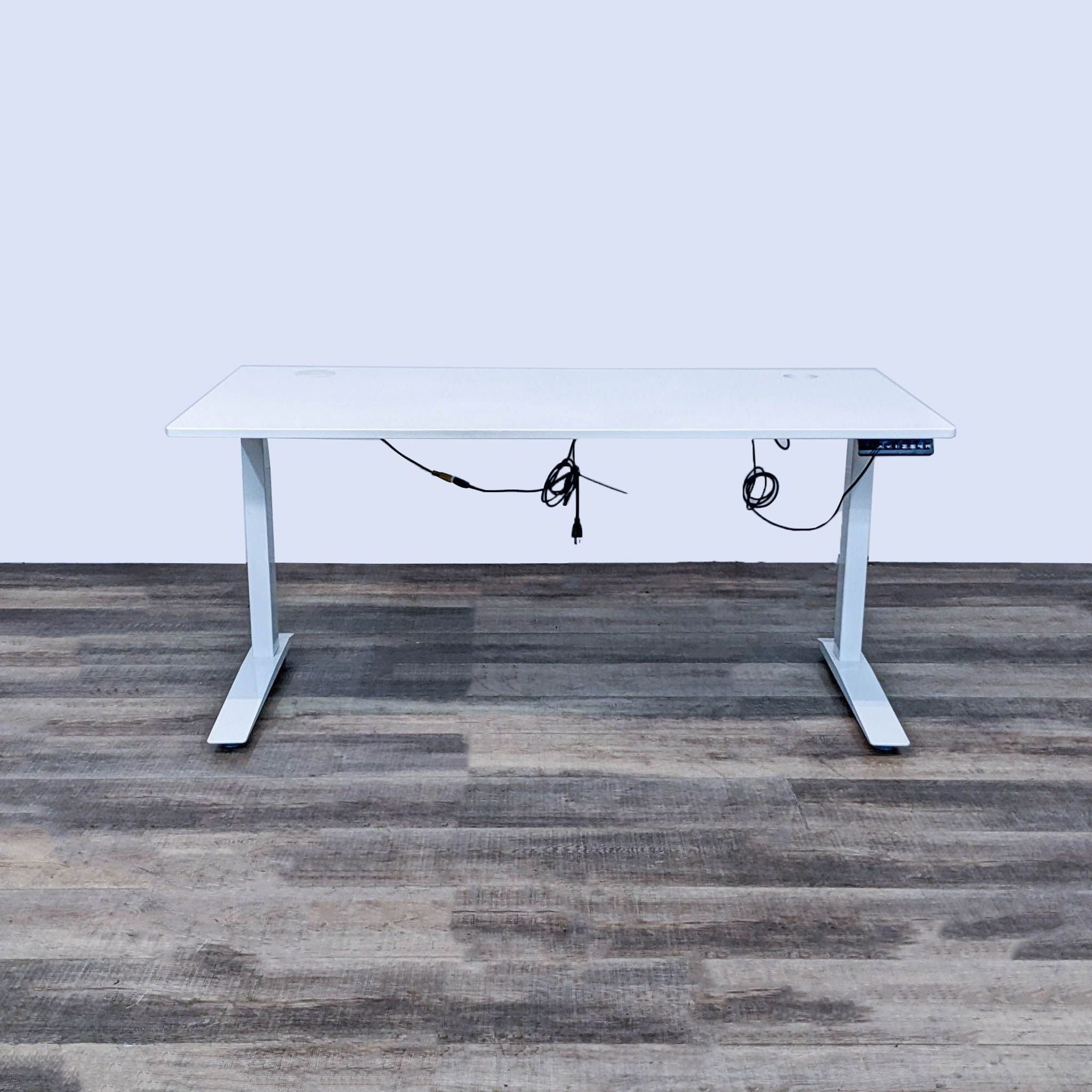 Reperch motorized white desk with height control on a steel frame, against a wooden floor and plain background.
