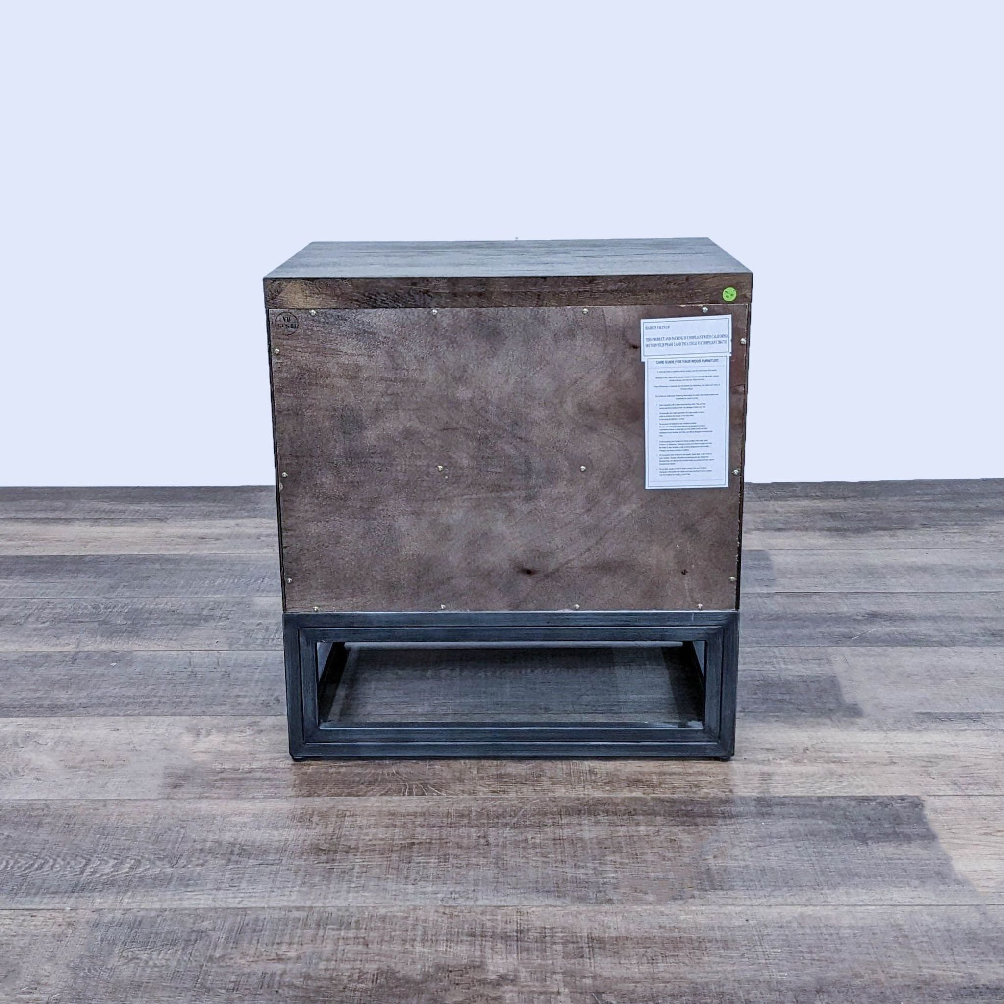 Reperch End Table with metal base, displaying the back view with a label, on a wooden floor.