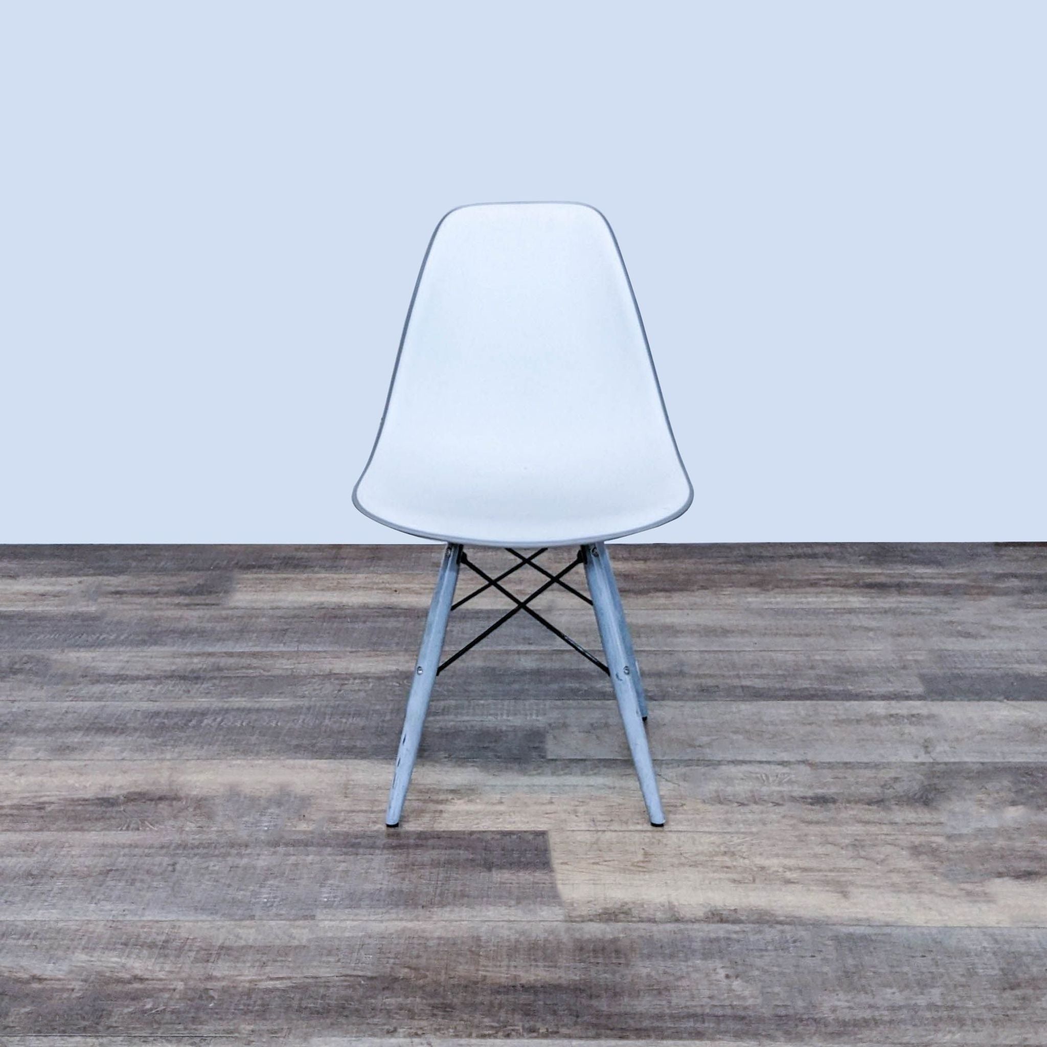 Reperch brand two-toned dining chair with contoured seat and wooden legs with metal Eiffel base on wooden floor.