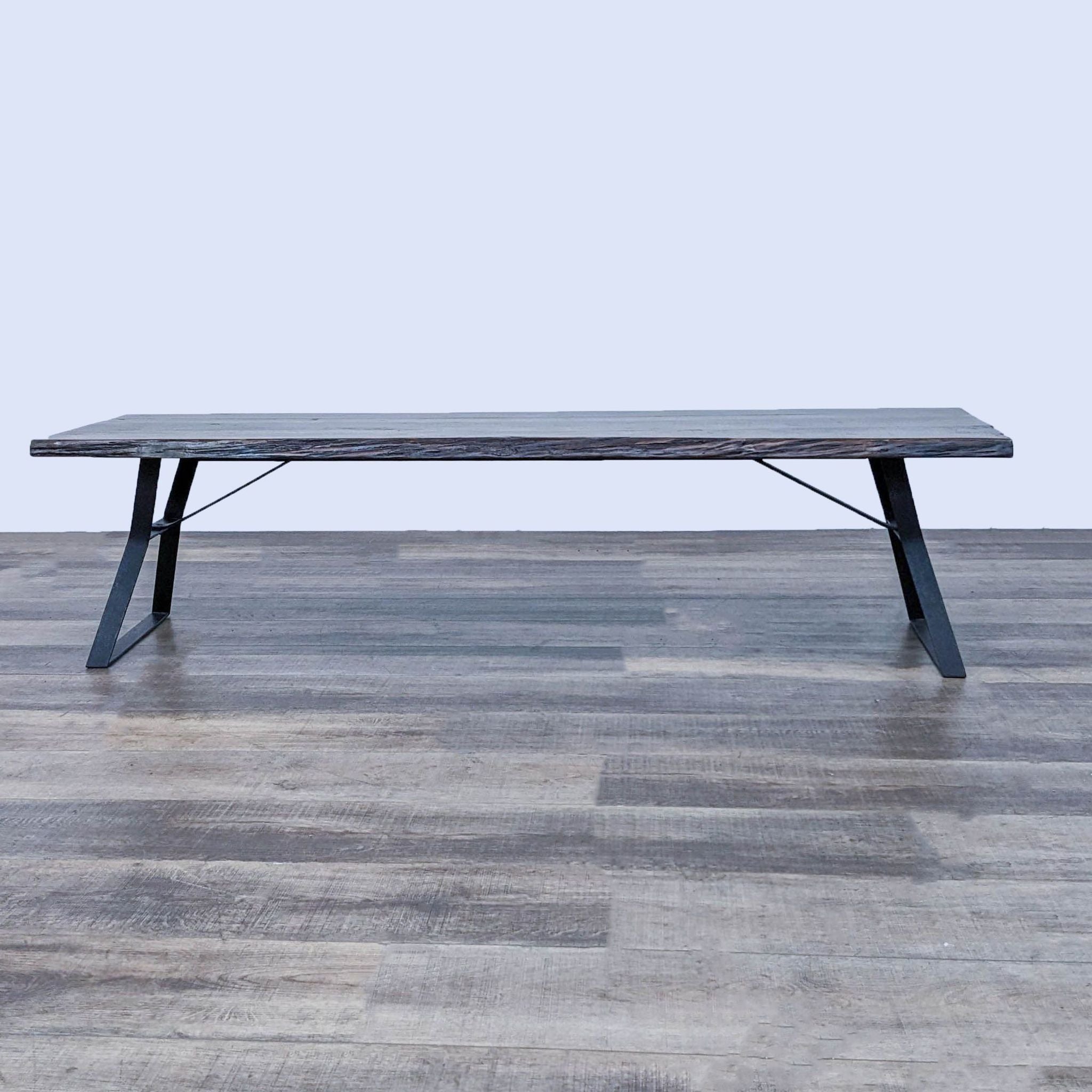 Reperch brand coffee table with metal base and dark wooden top on a wooden floor.