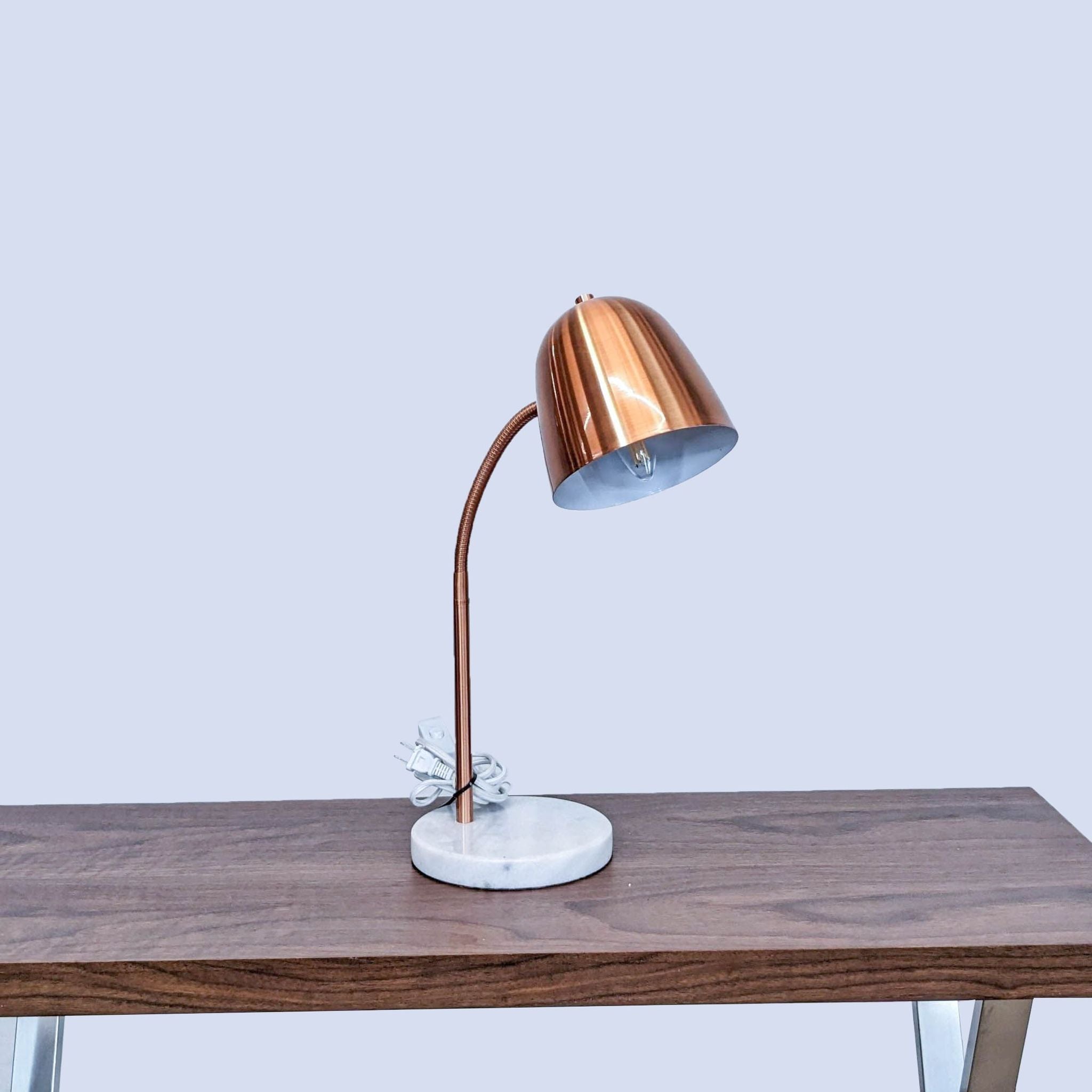 Reperch brand modern desk lamp with copper shade and marble base on a wooden table.