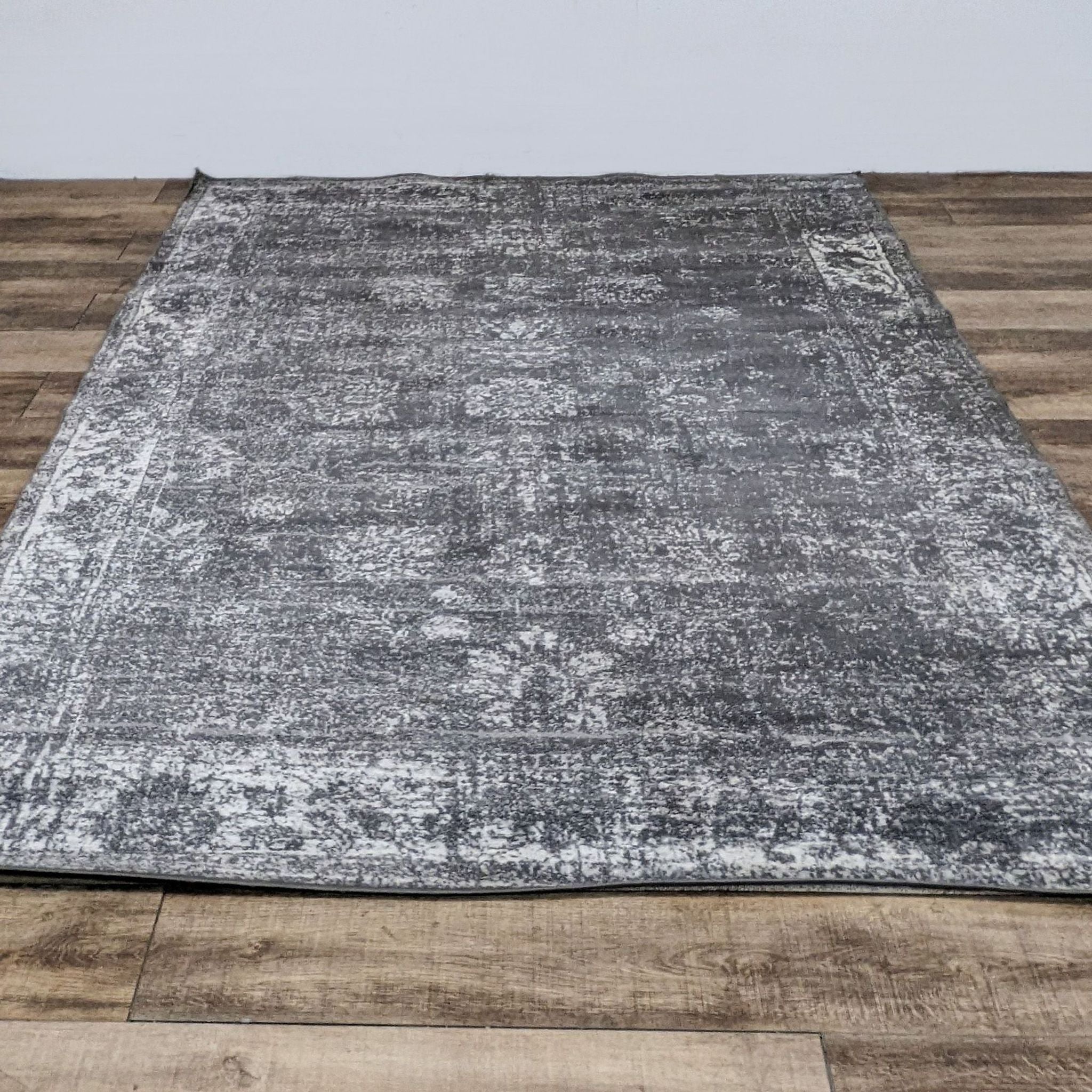 Sofia area rug by Unique Loom with a distressed gray pattern, medium pile, and laid on wooden flooring.