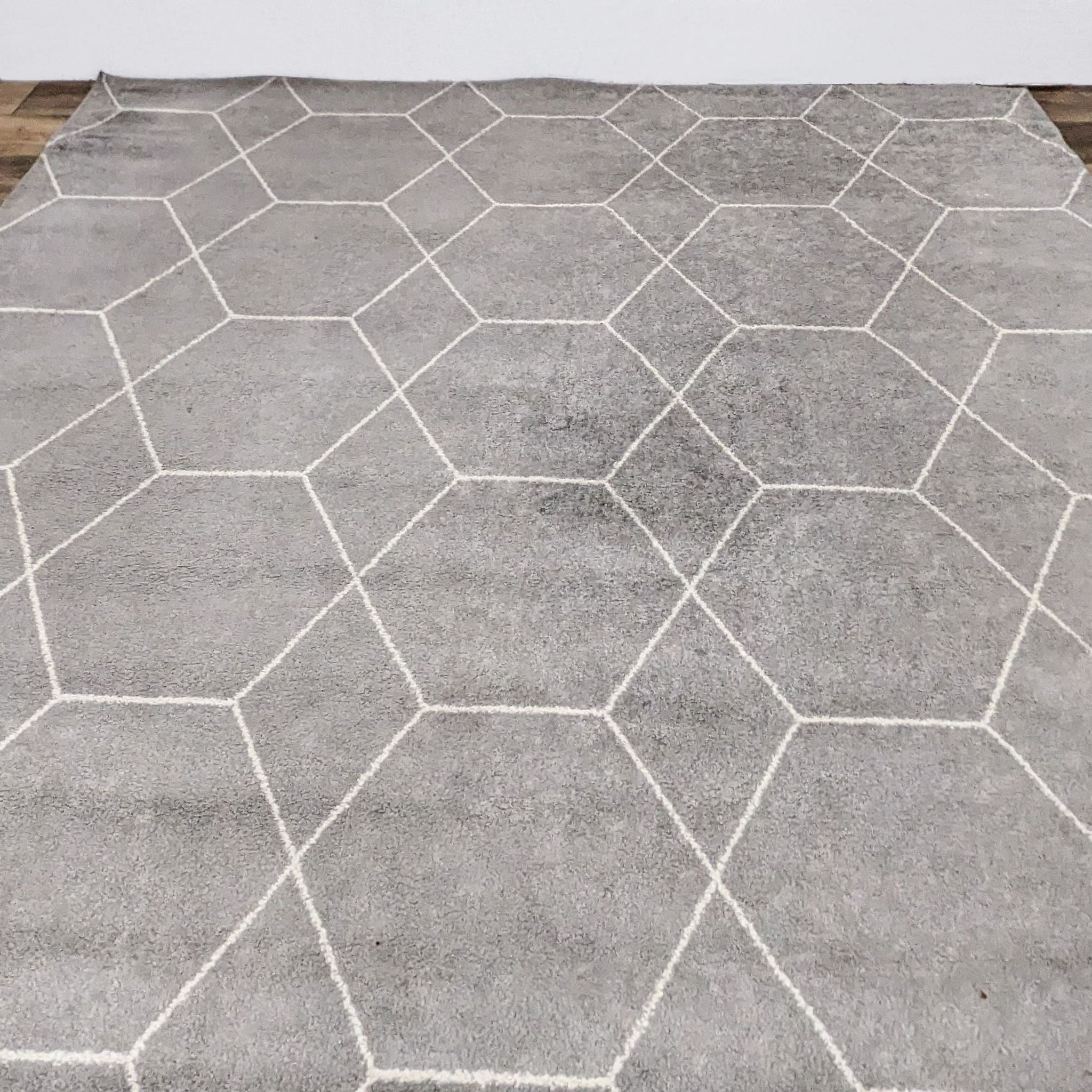 Ivory medium pile area rug with geometric trellis pattern by Unique Loom on a wooden floor.