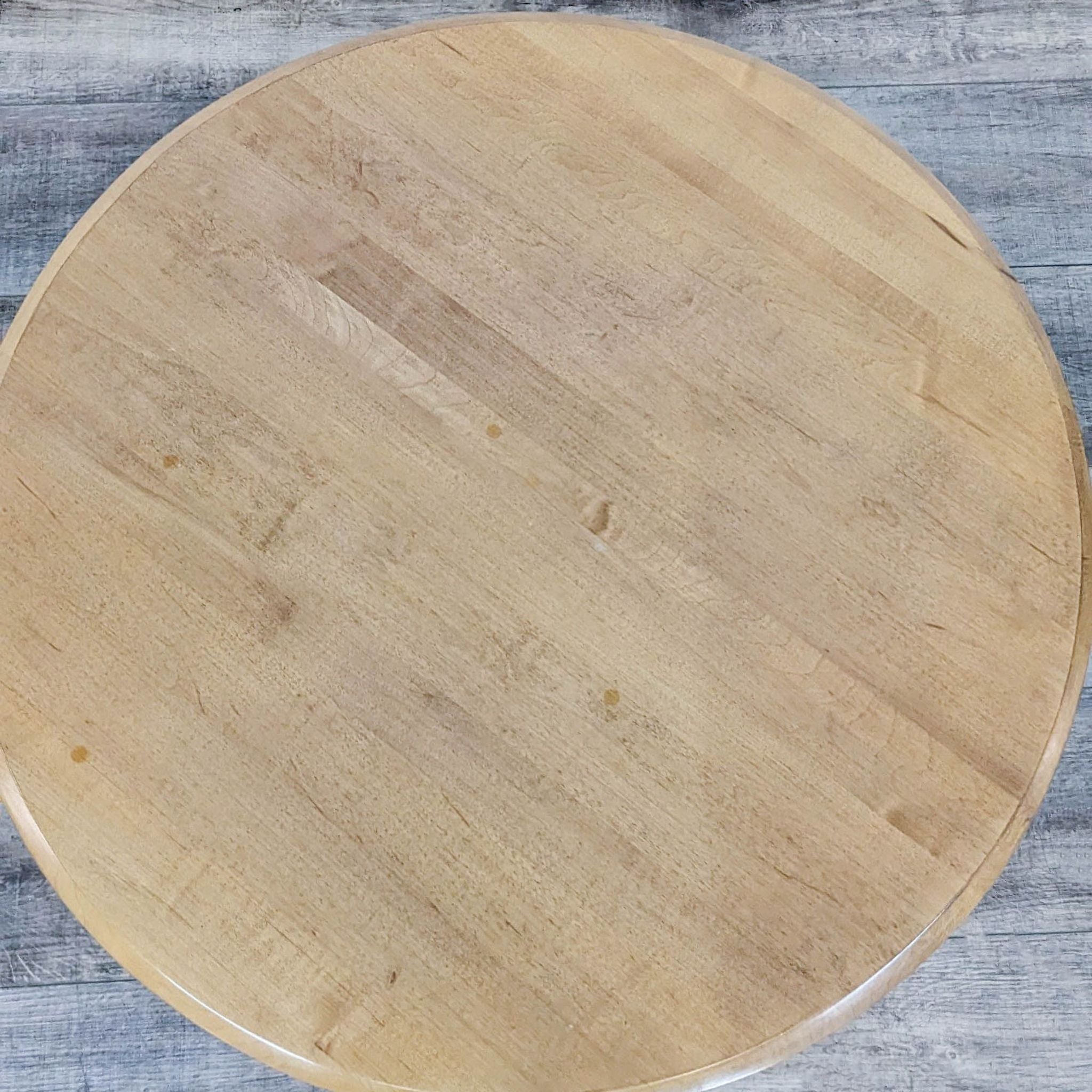 Top view of a round Ethan Allen end table showcasing the natural wood grain pattern.