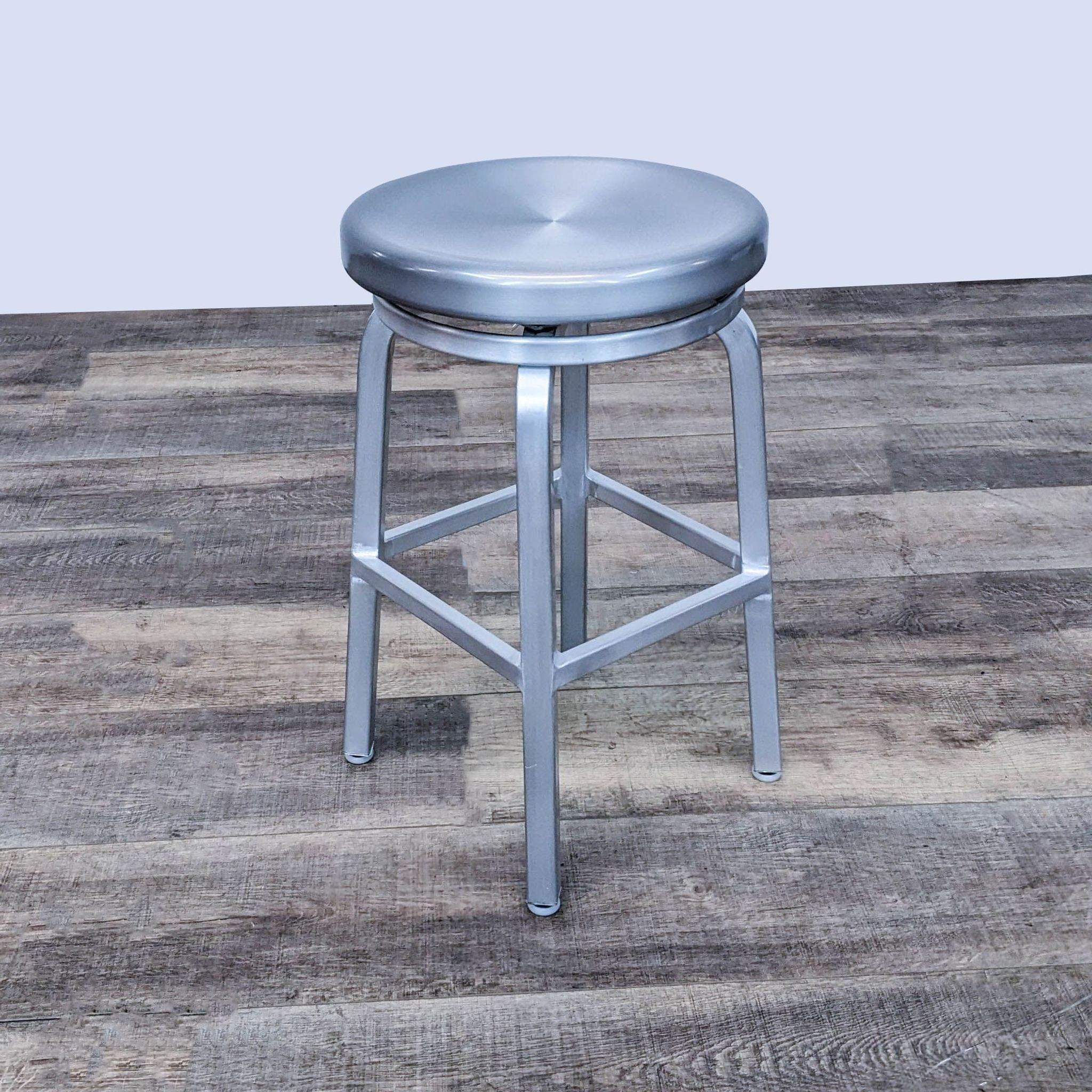Reperch industrial-style metal stool with a swivel seat on a wooden floor.