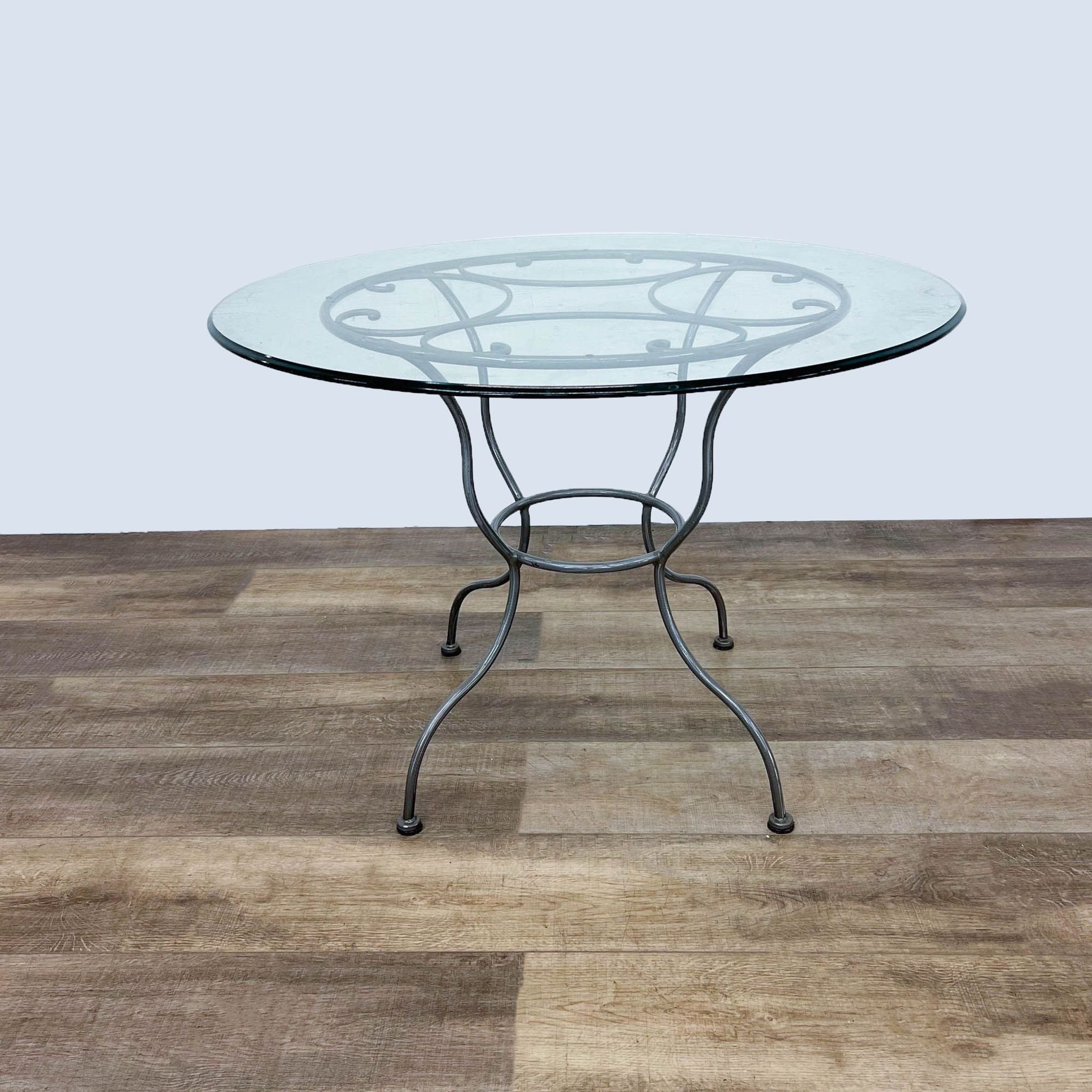 Reperch brand contemporary dining table with tempered glass top and metal base, viewed from an angle.