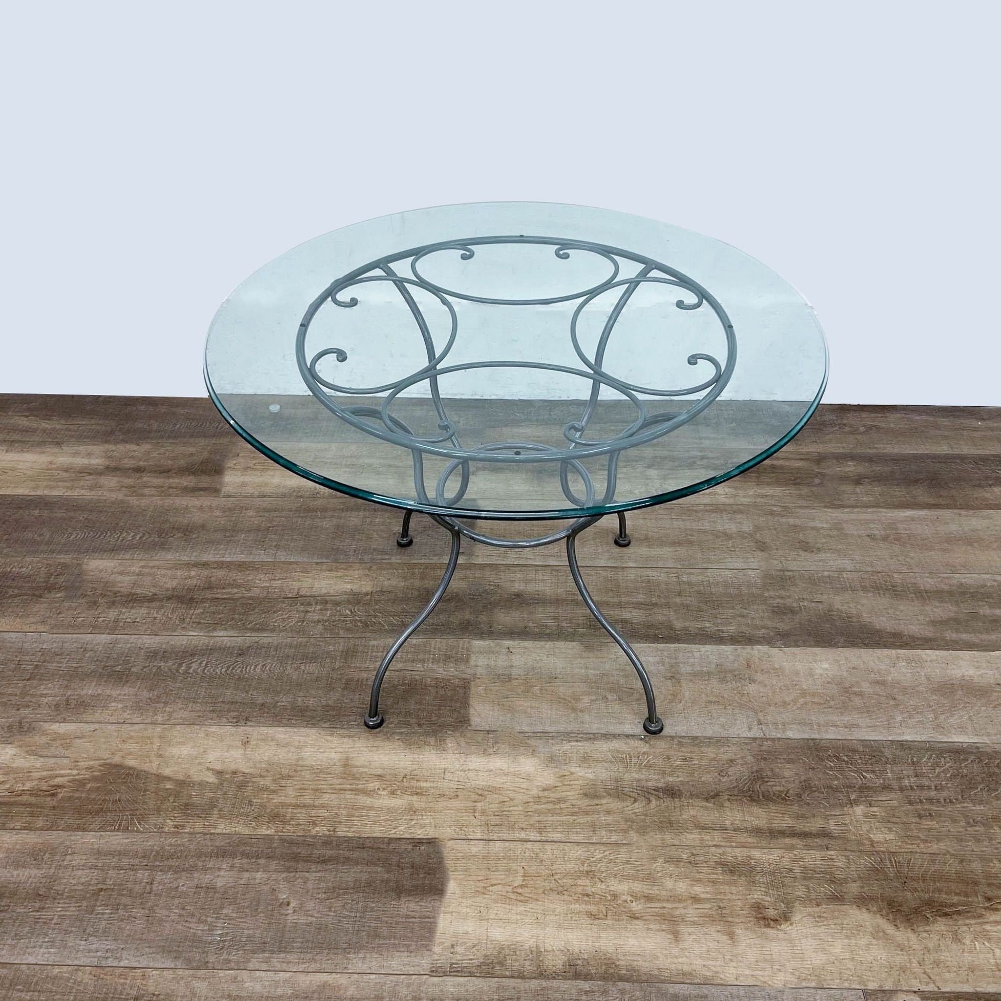 Reperch brand contemporary round dining table with a tempered glass top and powder-coated metal base, suitable for indoor/outdoor use.