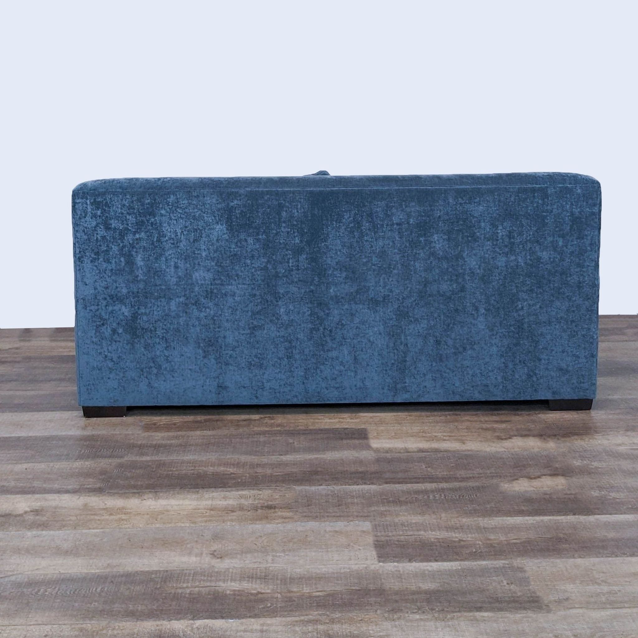 Rear view of Harvest Furniture's blue fabric high-back 3-seat sofa with block arms on a wooden floor.
