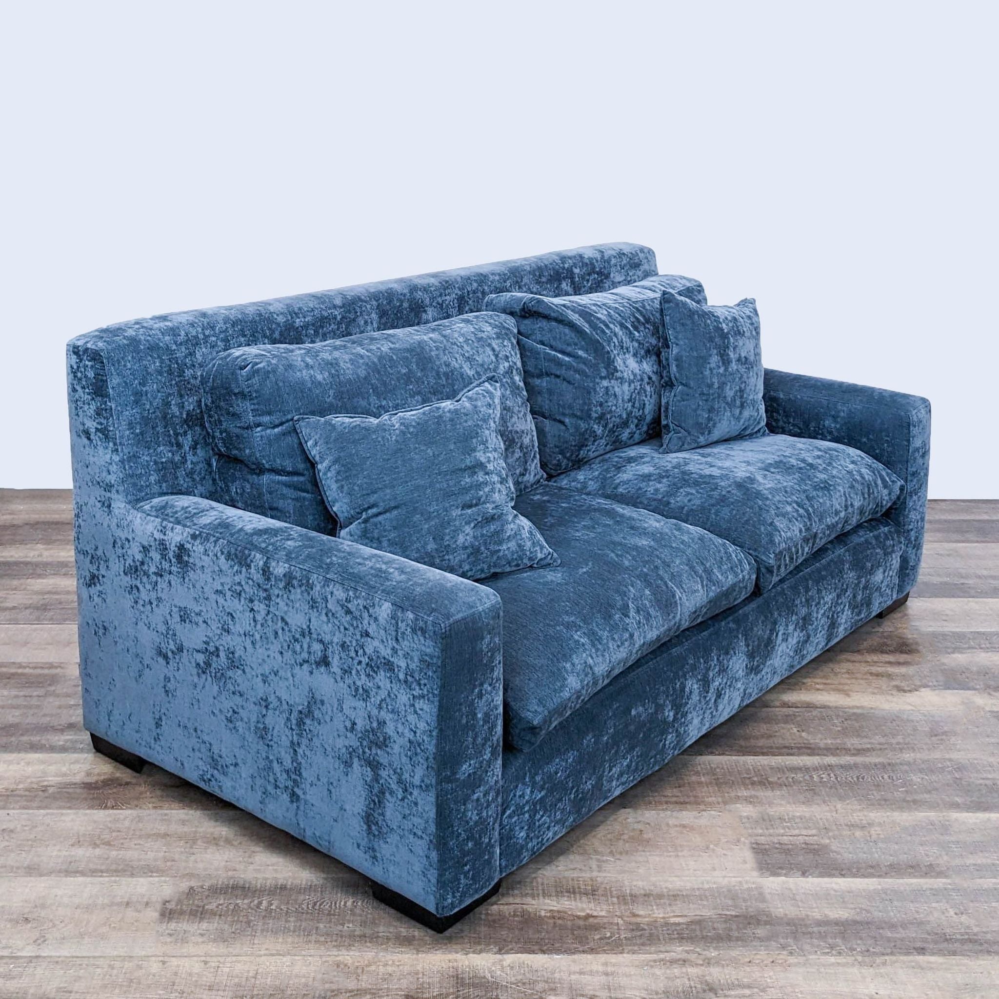 Alt text 2: Angled view of a plush blue Harvest Furniture sofa, showcasing its transitional styling and comfortable three-seat design.