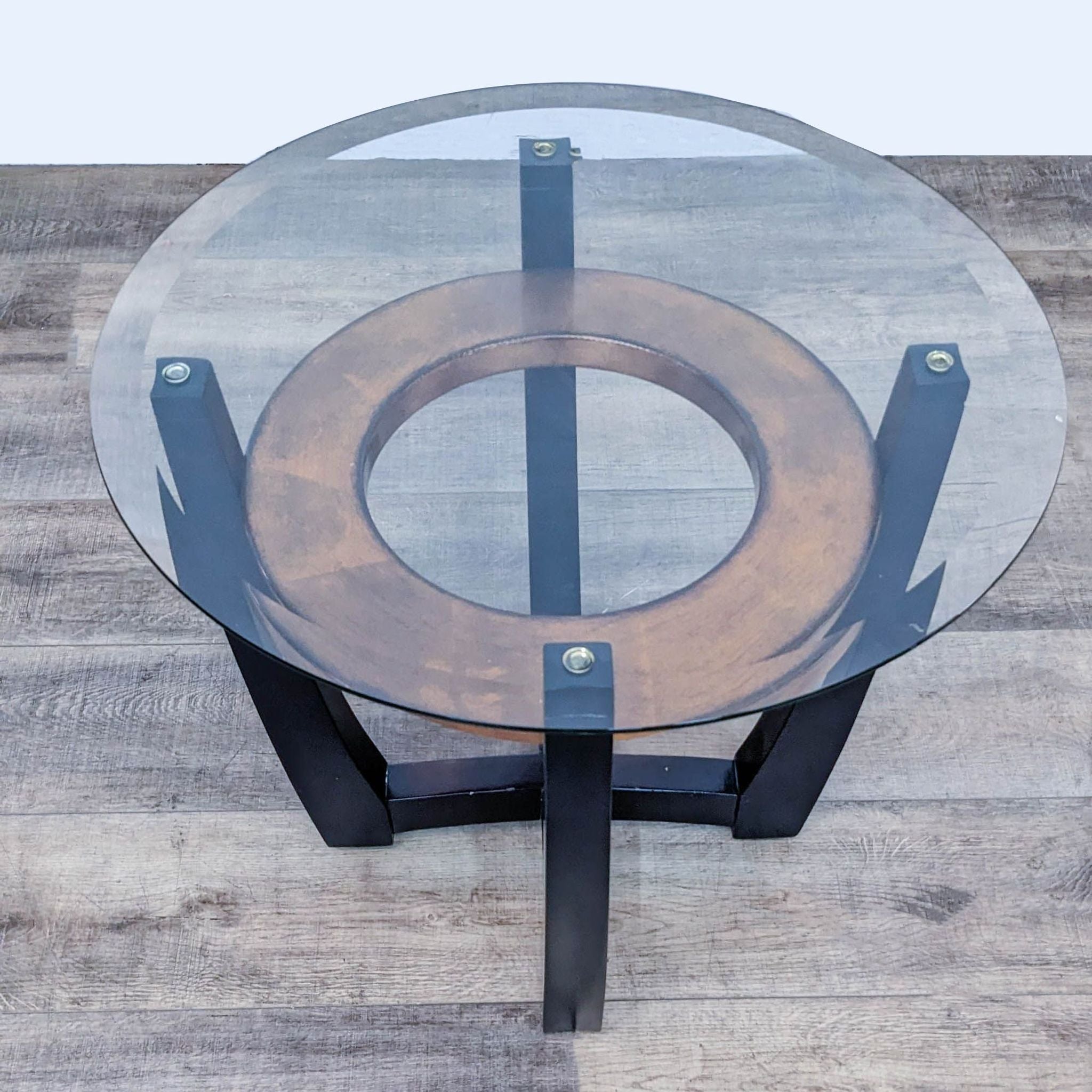 Reperch End Table with a transparent round glass top and circular wood base connected by black metal supports.