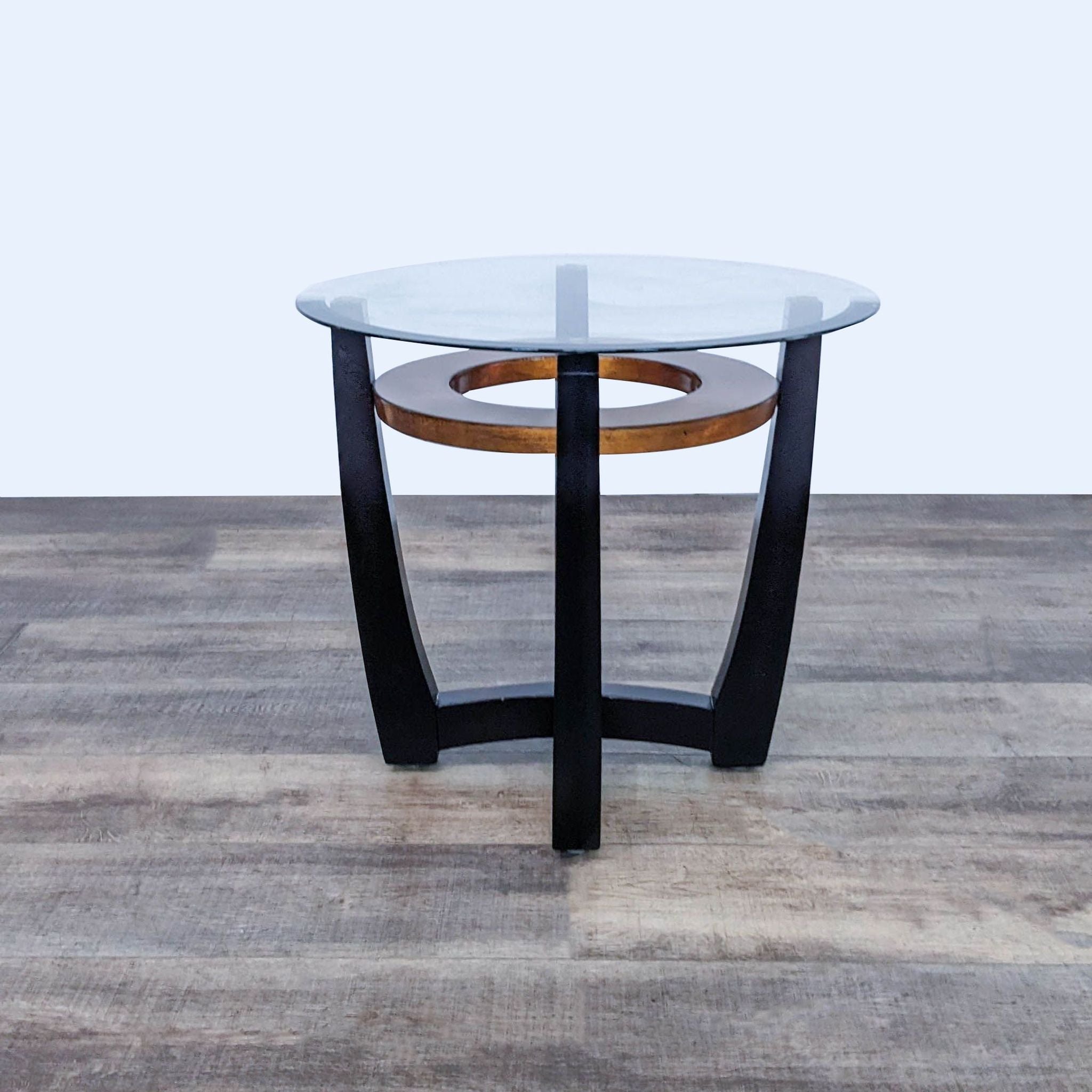 Top view of Reperch end table showing glass surface and round wooden detail on a black wood base.