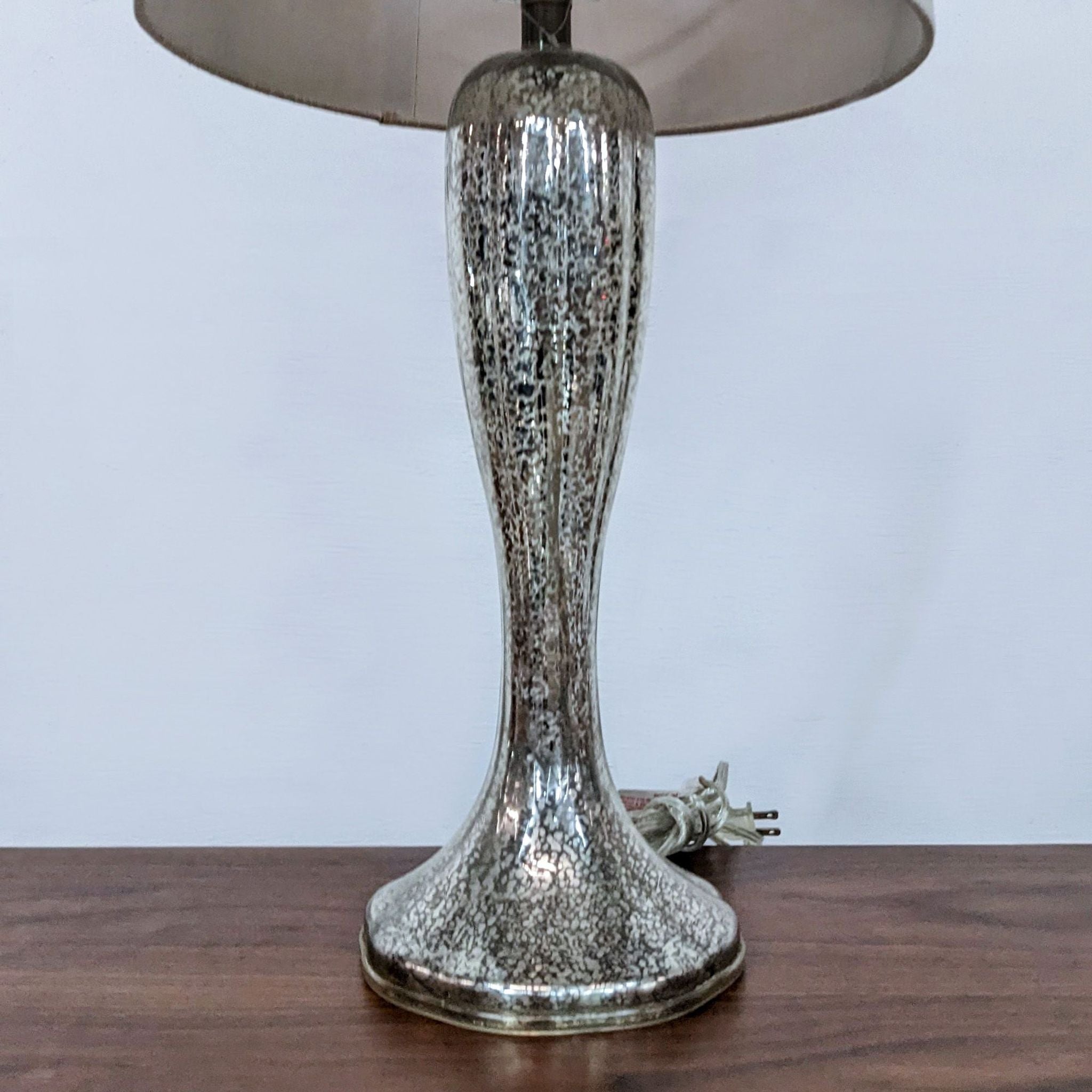 Alt text 2: Close-up of a Reperch table lamp's silver base and installed white spiral light bulb, with the lamp's shade frame visible.