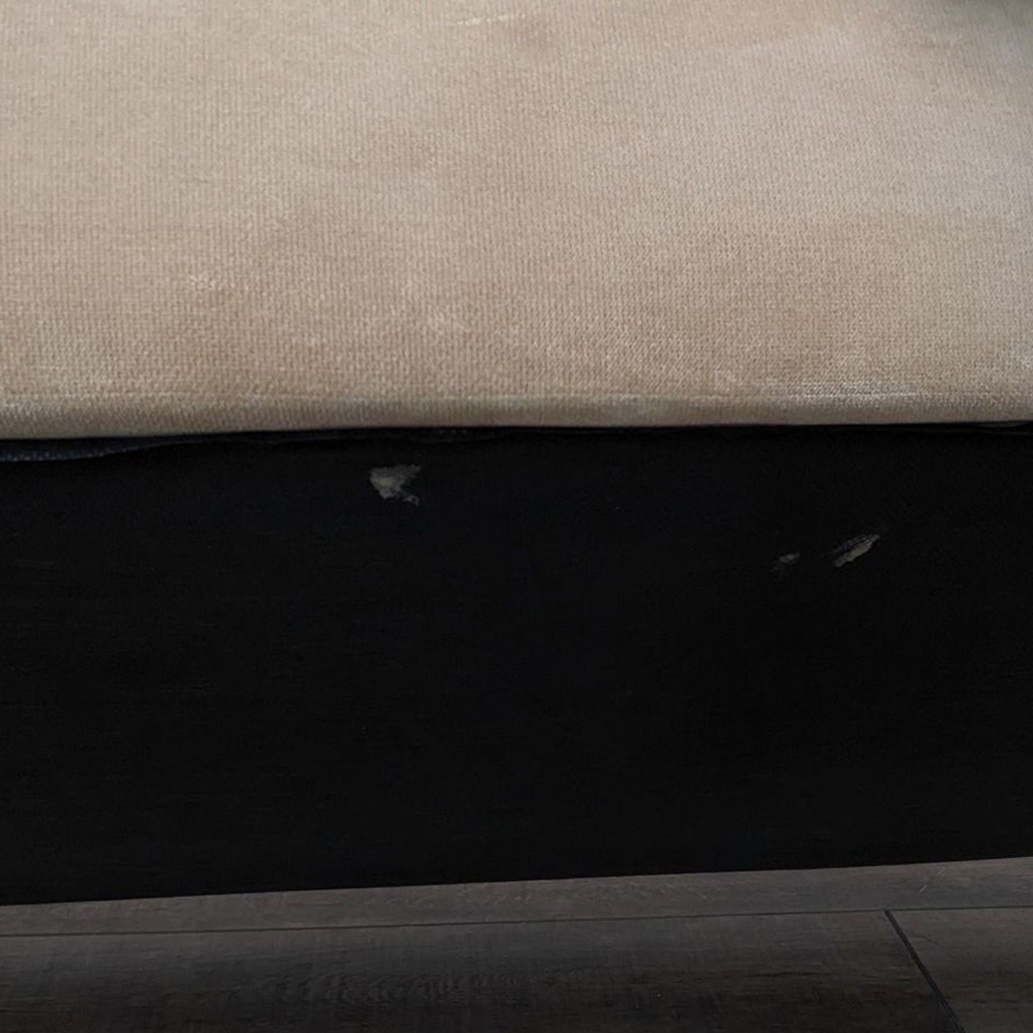 Close-up of the Reperch sofa's fabric detail, highlighting contrasting piping and wood feet, against a wood floor.