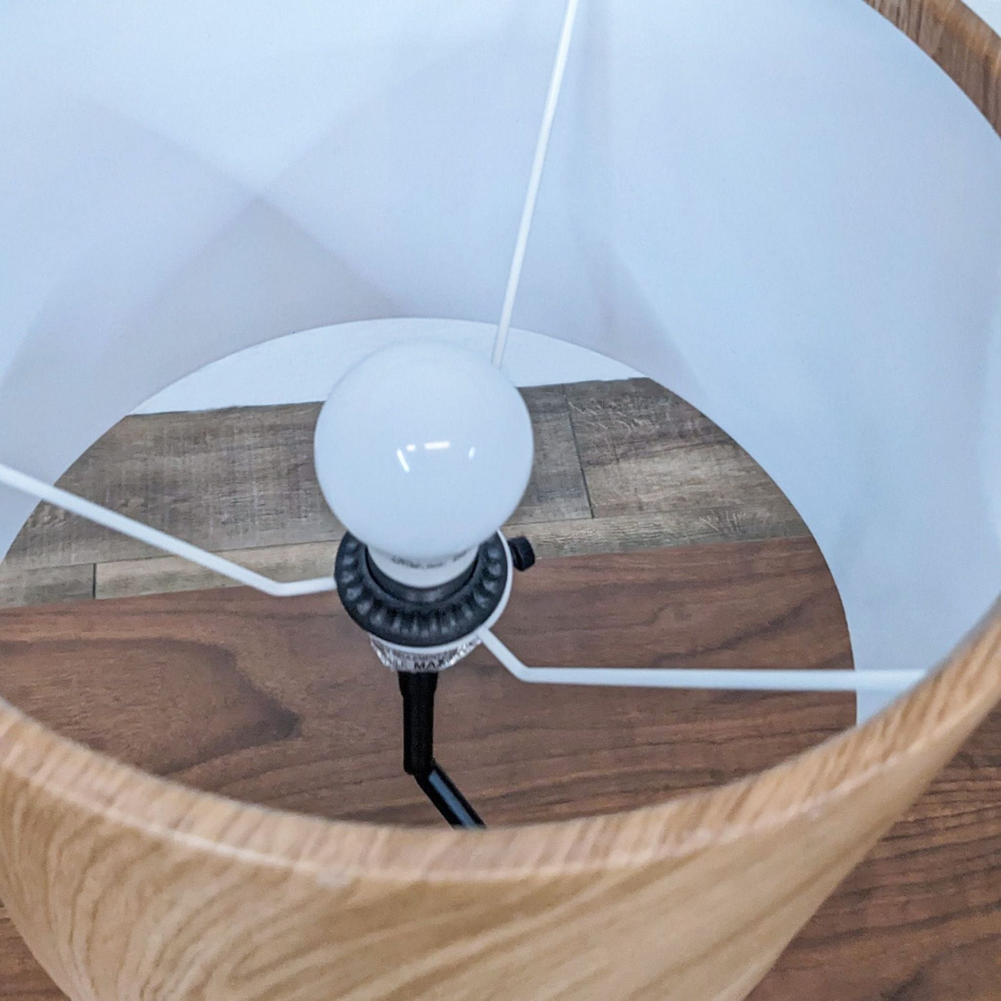 Alt text 2: Close-up of a Reperch table lamp showing the bulb and inner white shade, with a wooden outer shade.