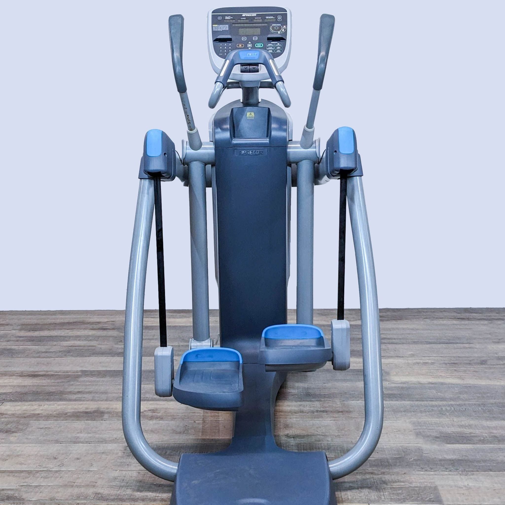 Precor elliptical machine with blue and gray colors, digital display, in a gym setting.