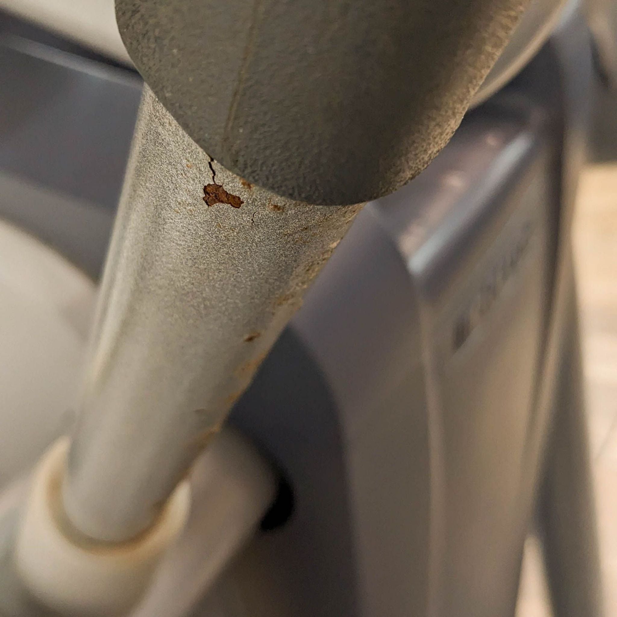 Close-up of rust on the metal part of a Precor gym elliptical equipment.
