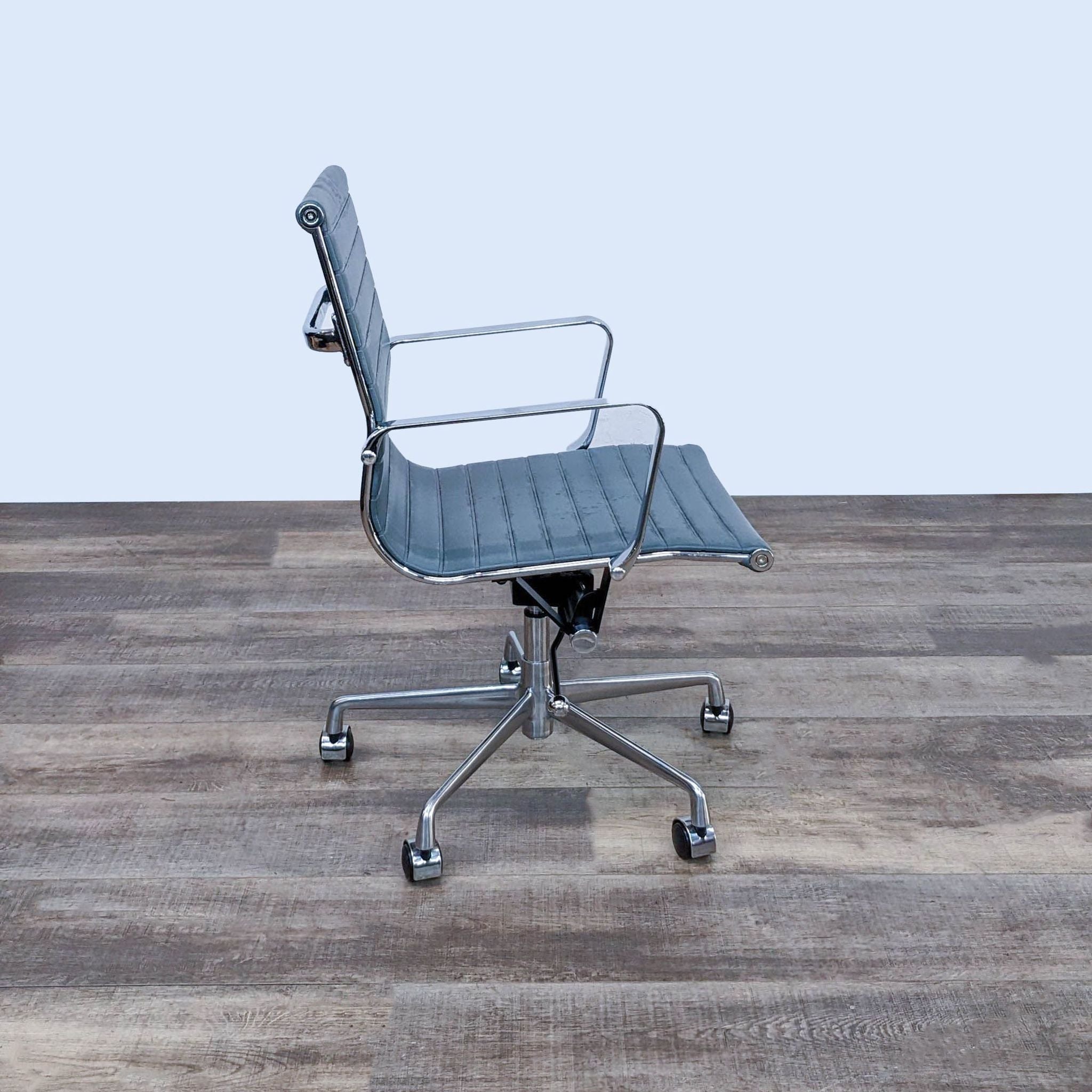 Chrome-finished metal frame office chair by Reperch with adjustable height and embossed blue faux leather for breathability.