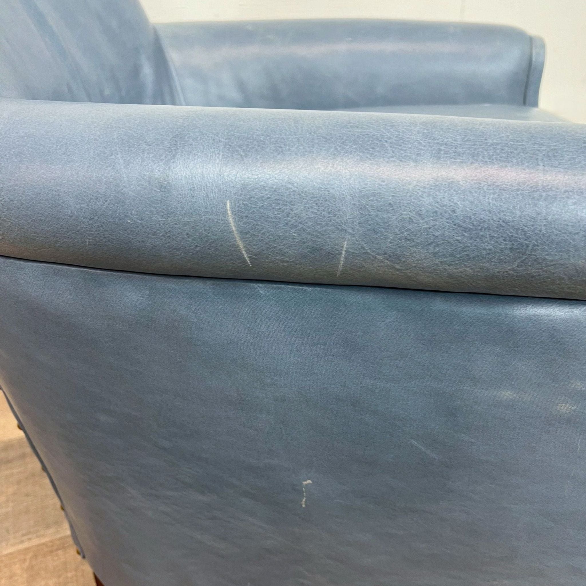 Close-up of Moore and Giles 33 Original lounge chair in leather with visible scratches.