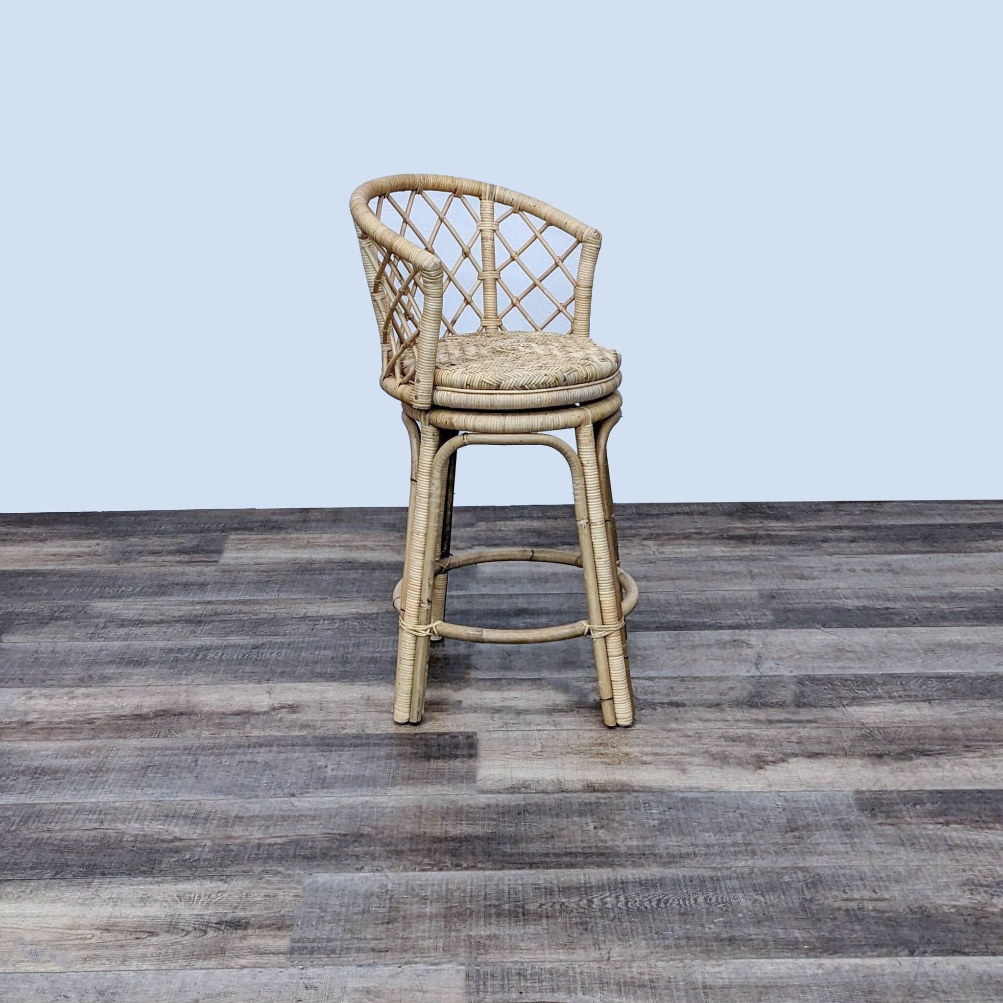 Natural-colored Rattan Swivel Stool by Serena and Lily with criss-cross back design.