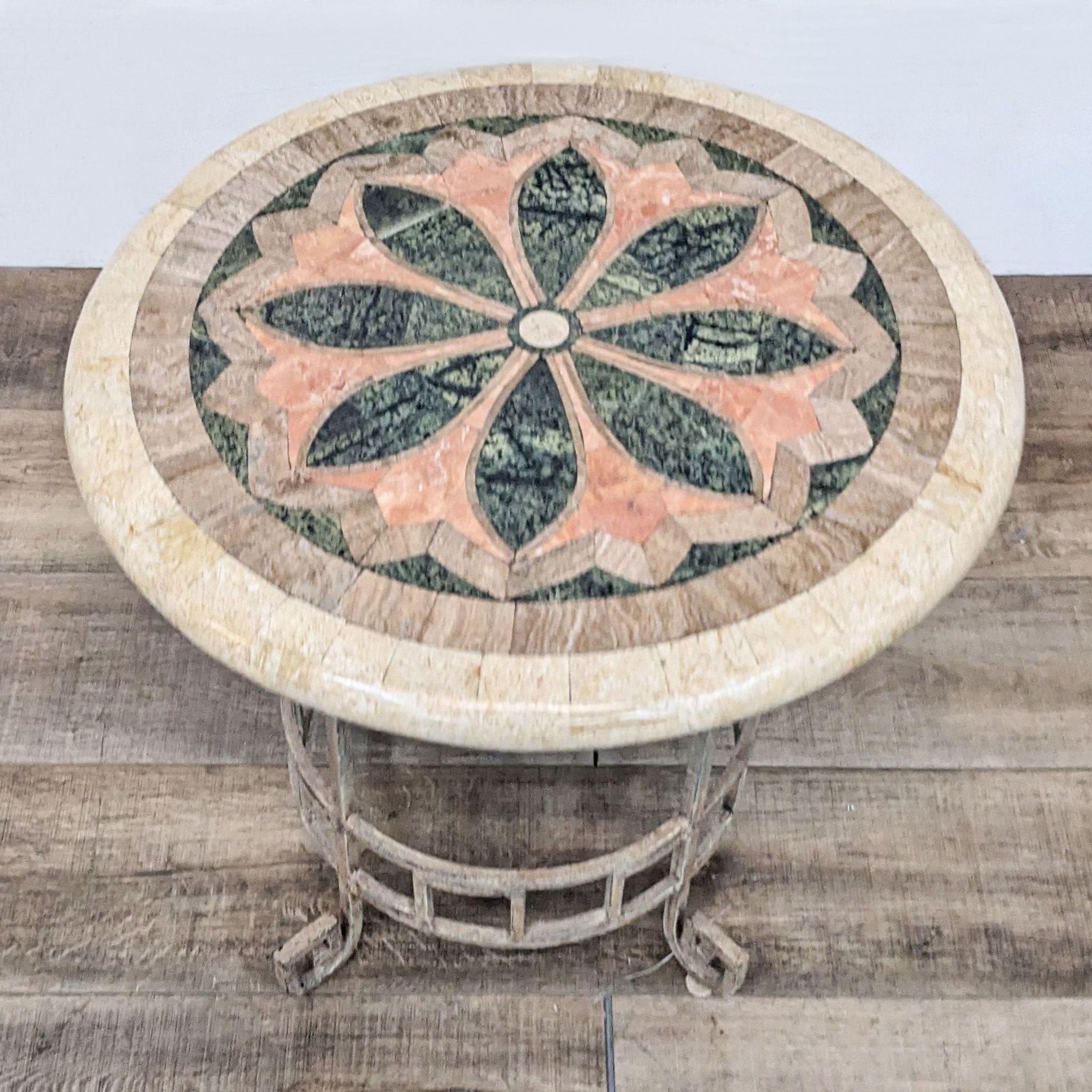 Reperch brand end table with a round, faux stone patterned top featuring a floral design, on a decorative base.