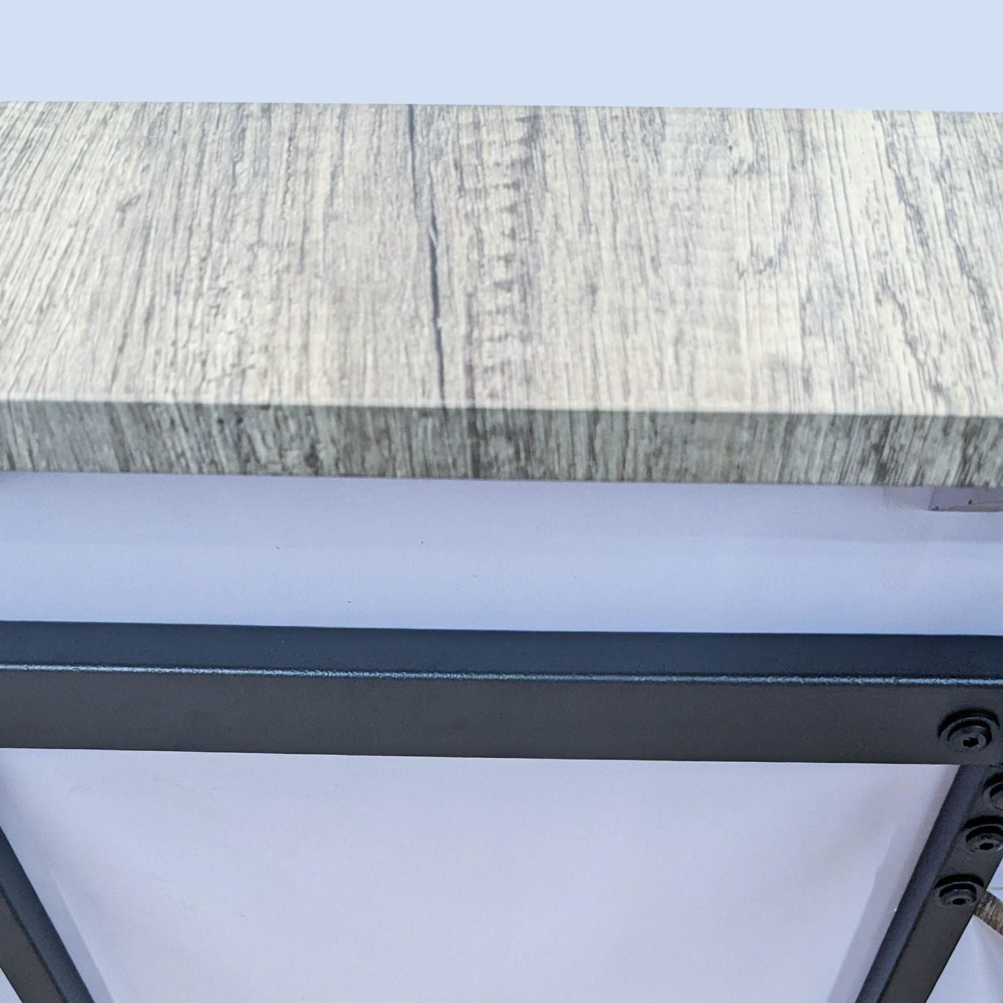 Reperch brand coffee table detail showing wooden top and metal frame construction.