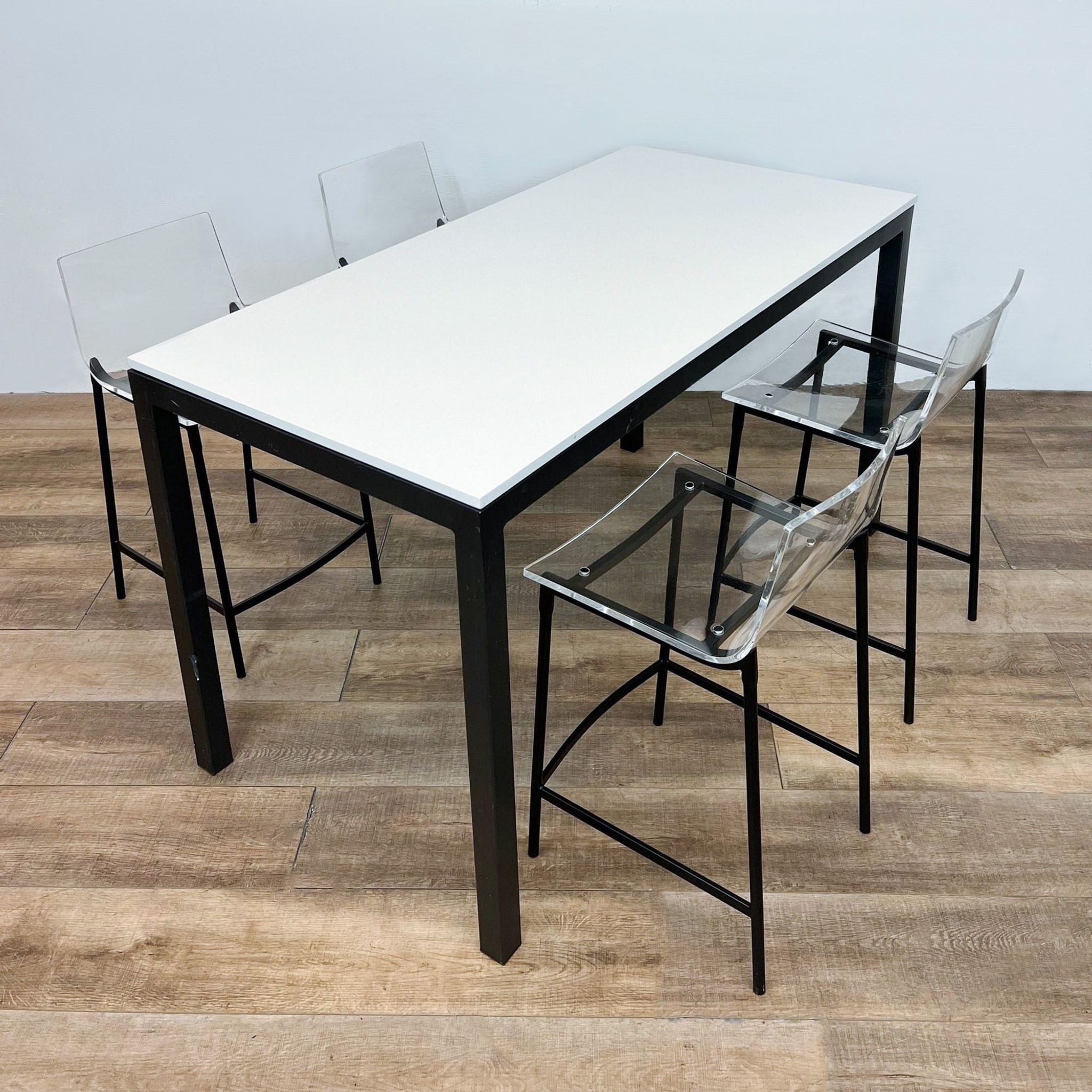 Room & Board Parsons counter height table with white quartz top and four CB2 Chiaro clear acrylic stools with black steel legs.