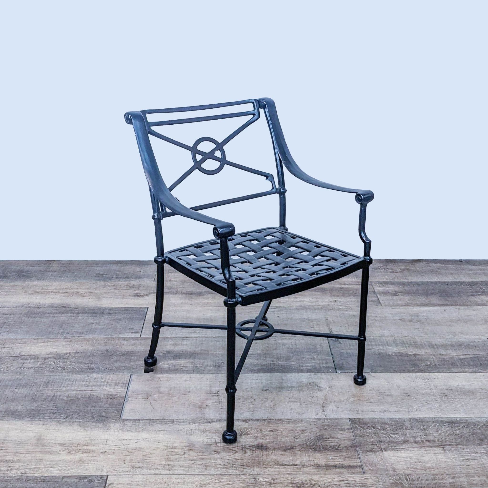 Powder-coated Reperch classic chair featuring circle backrest design and interwoven seat pattern, displayed on wooden flooring.