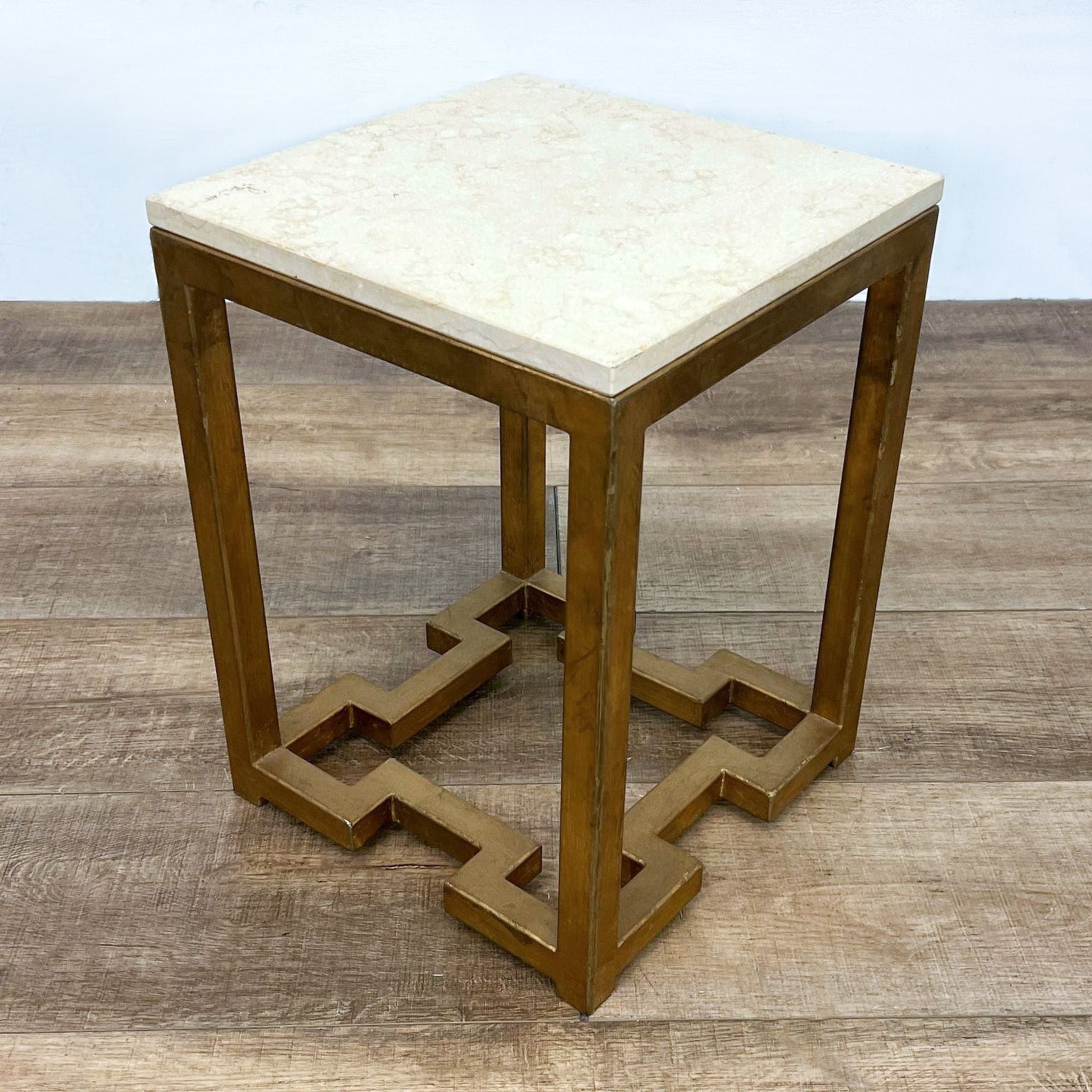 Square top console table by Reperch with antiqued brass finish base, featuring geometric design elements.