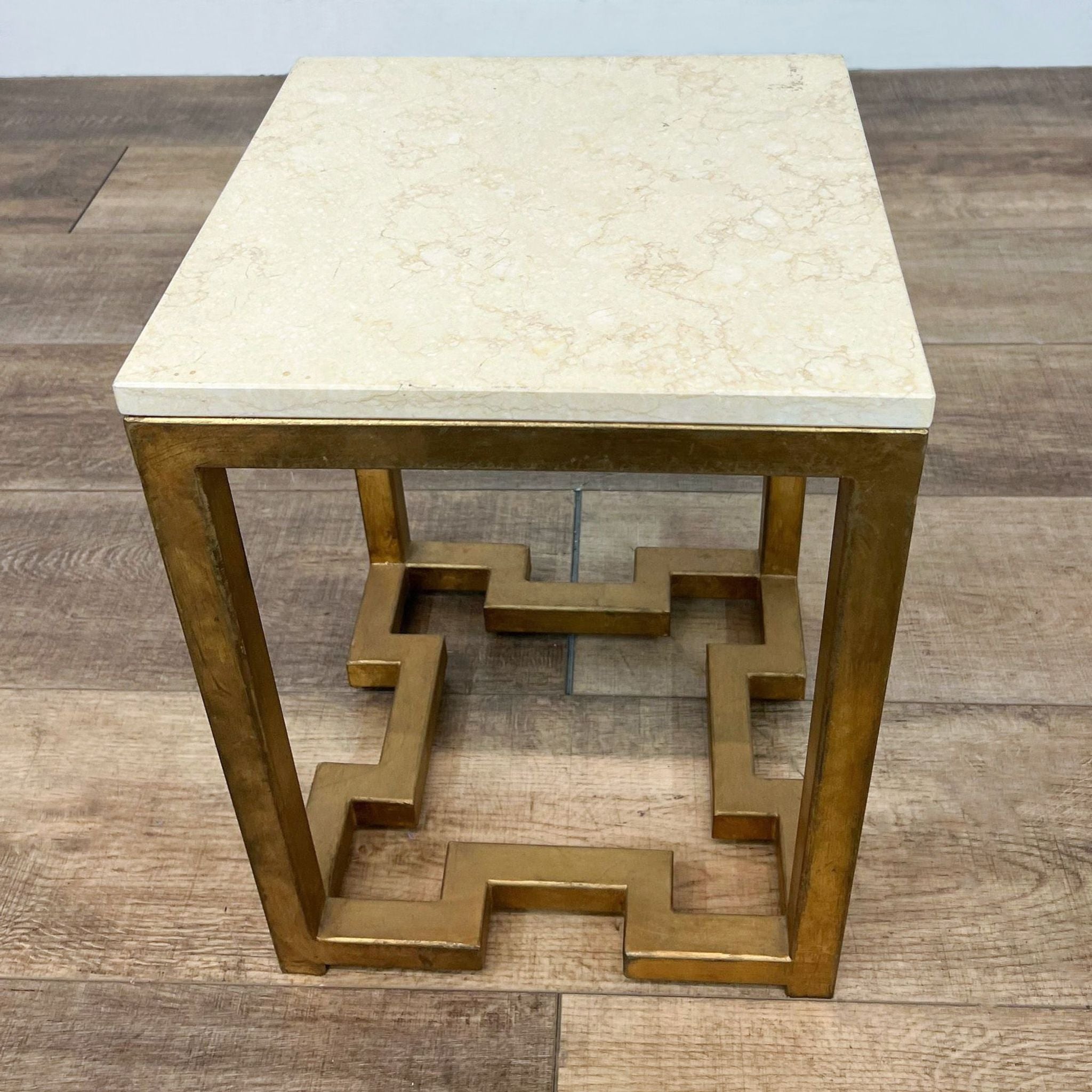 Reperch brand side table with antiqued brass finish metal base and cream-colored stone top.
