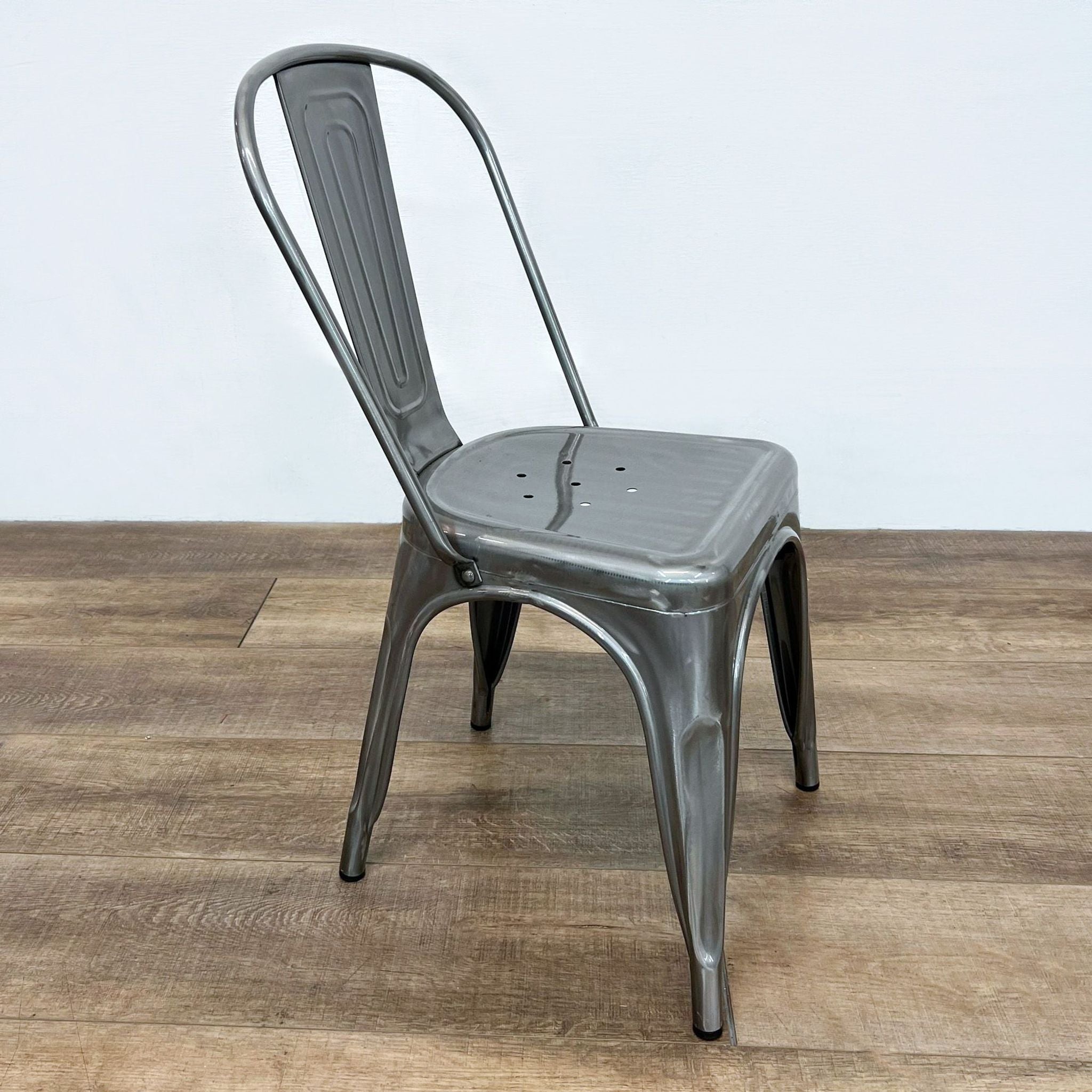 Sturdy Reperch dining chair featuring a metal build, curved backrest and compact, stackable shape for versatile seating.